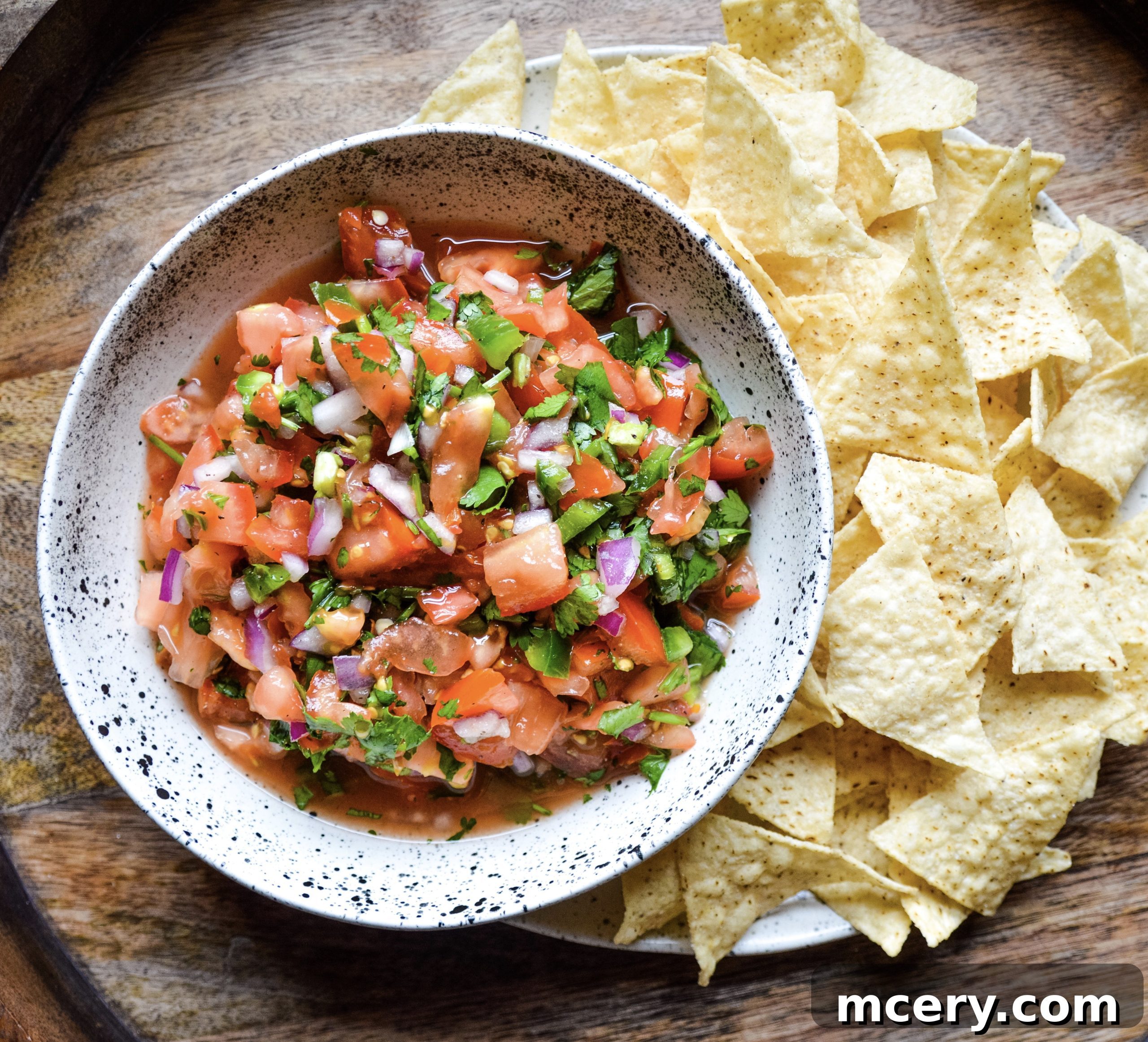 Zesty Garden Fresh Salsa 2 Freshly prepared Pico de Gallo in a rustic bowl, showcasing vibrant red tomatoes, white onion, and green cilantro, ready to be served.