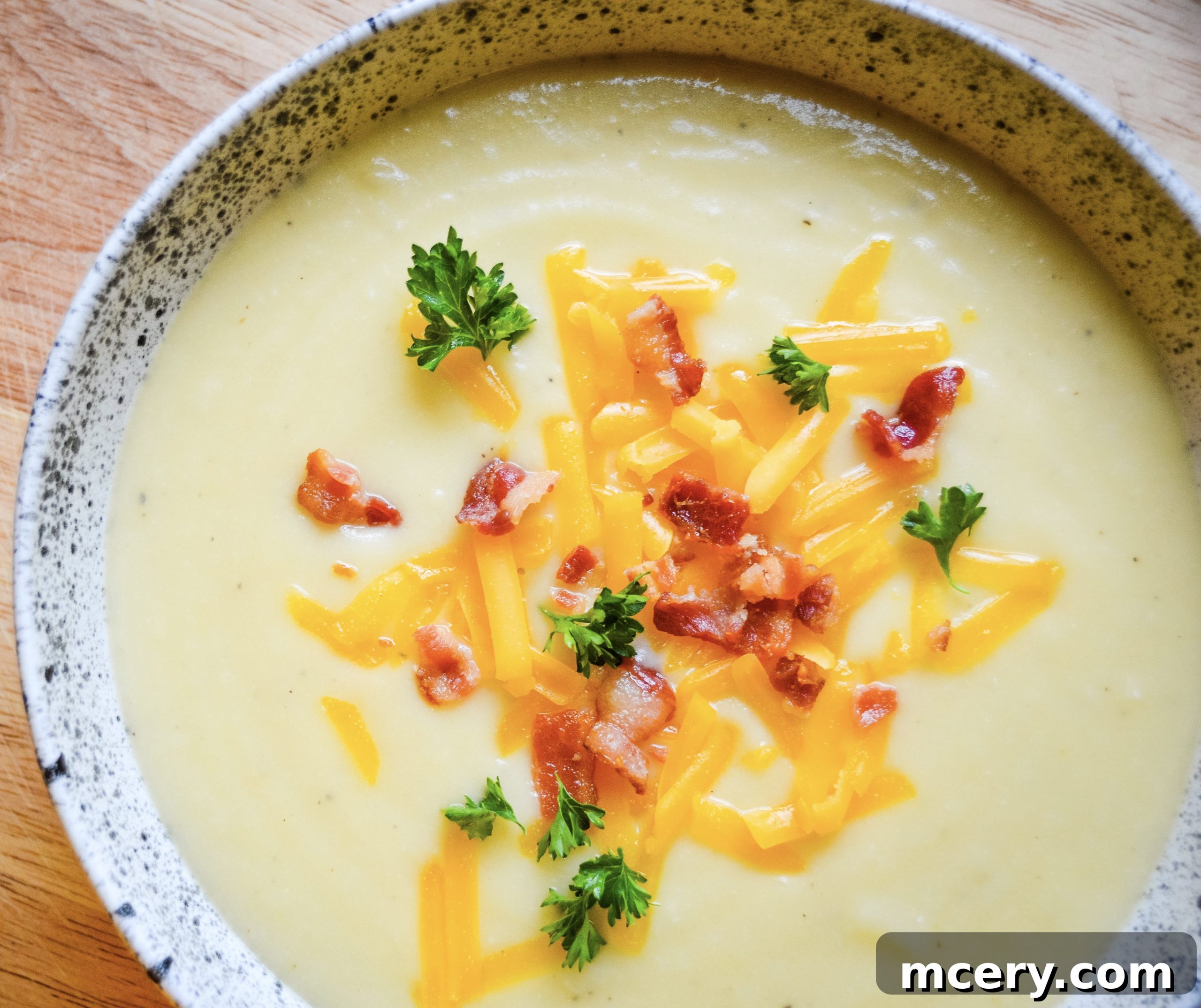 Instant Pot Velvety Cauliflower Cheese Soup 2 A heartwarming bowl of creamy cauliflower cheese soup, garnished with fresh herbs and a sprinkle of cheese, inviting warmth and comfort.