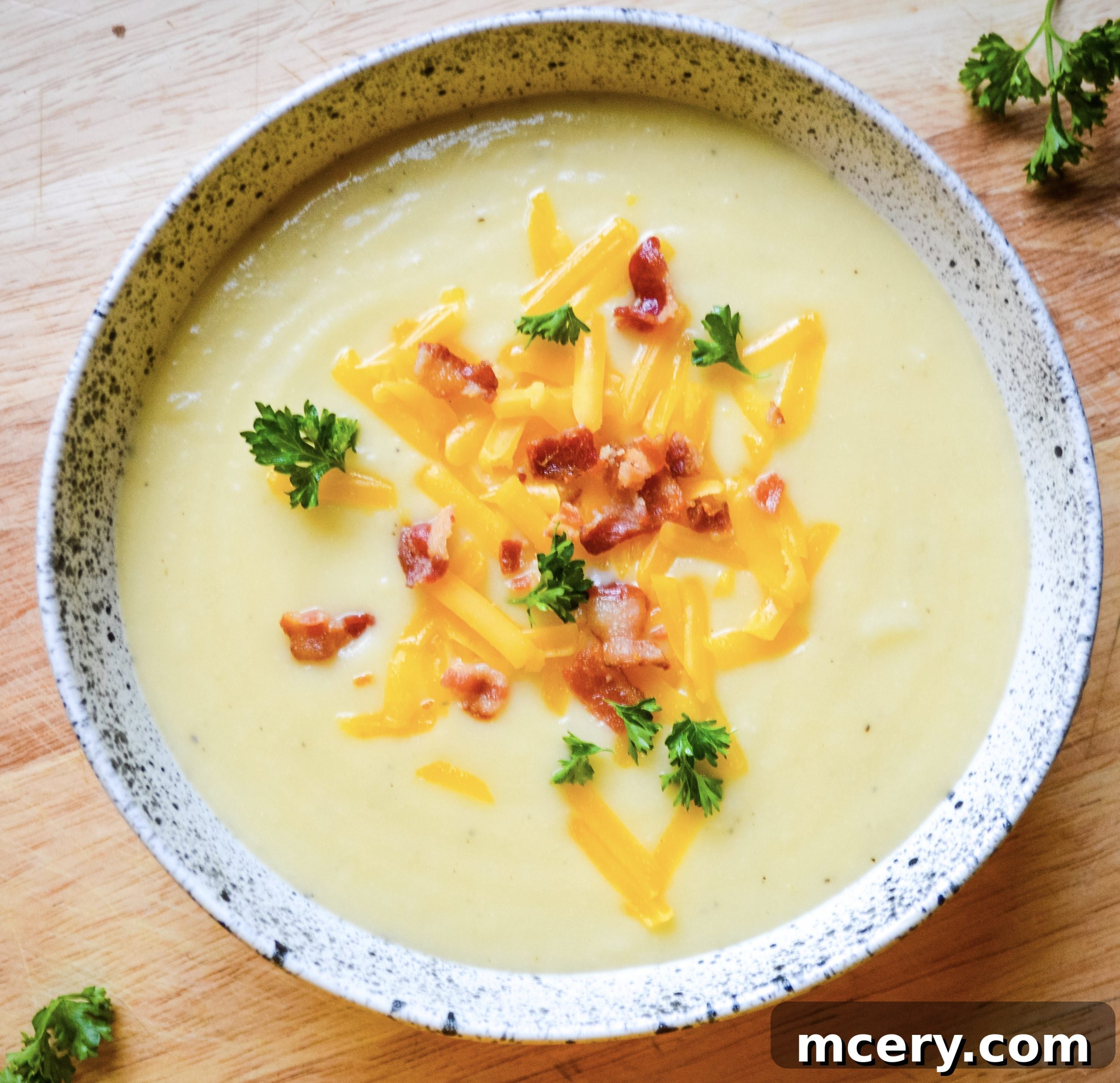 Instant Pot Velvety Cauliflower Cheese Soup 4 A rustic overhead shot of the cauliflower cheese soup in a bowl, with a spoon ready for a taste, promising warmth and flavor.