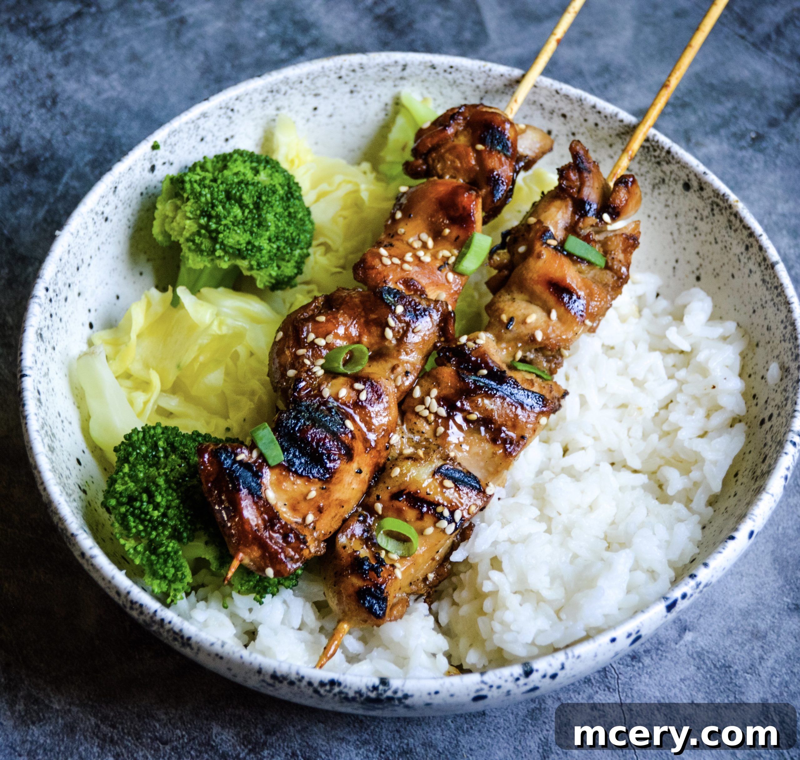 Sticky Teriyaki Chicken Skewers 3 Three Teriyaki Chicken Skewers plated, with one skewer in focus showing the glazed chicken pieces and the char marks from grilling.
