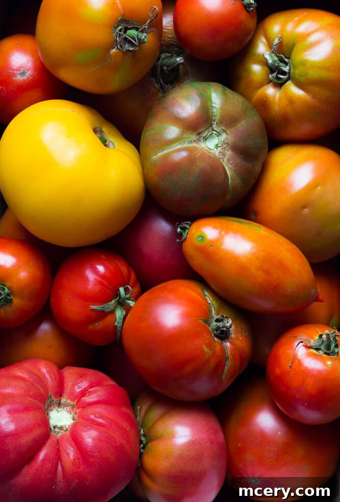 Summer Heirloom Tomato Stack 2 Crisp, golden-brown toast base generously spread with a bright green garlic-herb mayonnaise, topped with thick, colorful slices of juicy heirloom tomatoes. A delightful and fresh meal.