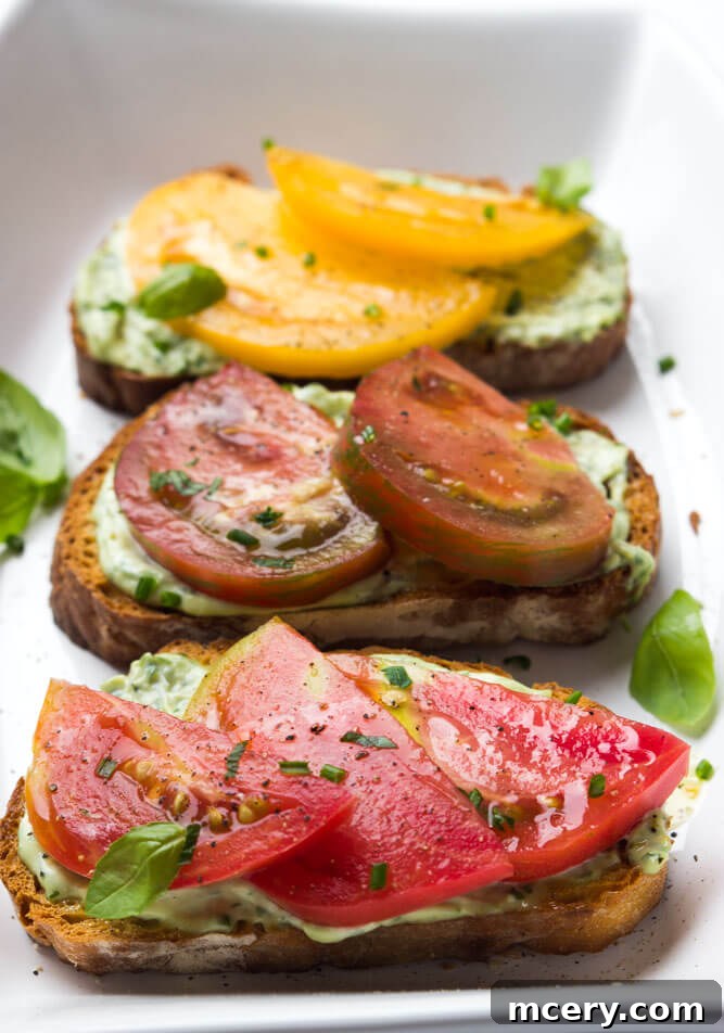 Summer Heirloom Tomato Stack 3 Close-up of vibrant, multicolored heirloom tomato slices arranged on a cutting board, showcasing their irregular shapes and rich colors, ready for sandwich assembly.