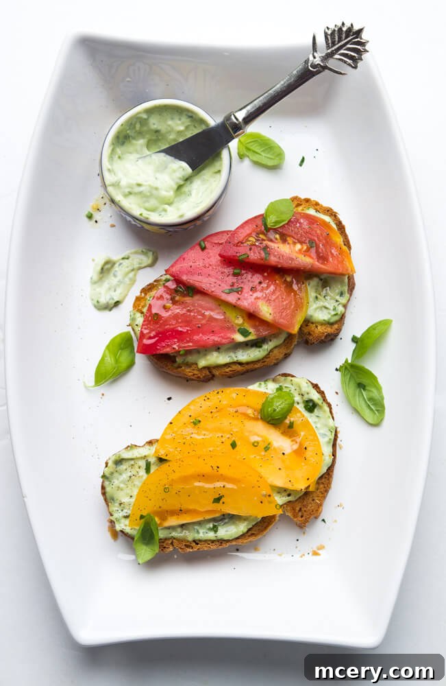 Summer Heirloom Tomato Stack 5 Ingredients for garlic-herb aioli laid out: fresh herbs, lemon, garlic cloves, olive oil, and a bowl of mayonnaise. Ready for blending into a creamy spread.