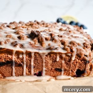 Moist Bakery Style Blueberry Burst Coffee Cake 16 A high-angle shot of a whole blueberry coffee cake with streusel and glaze.