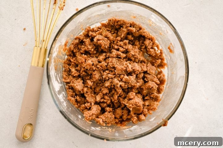 Moist Bakery Style Blueberry Burst Coffee Cake 7 Melted butter being added to dry streusel ingredients, forming crumbs.