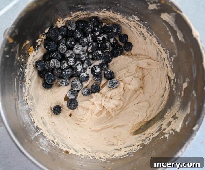 Moist Bakery Style Blueberry Burst Coffee Cake 10 Fresh blueberries lightly coated in flour being folded into the cake batter.