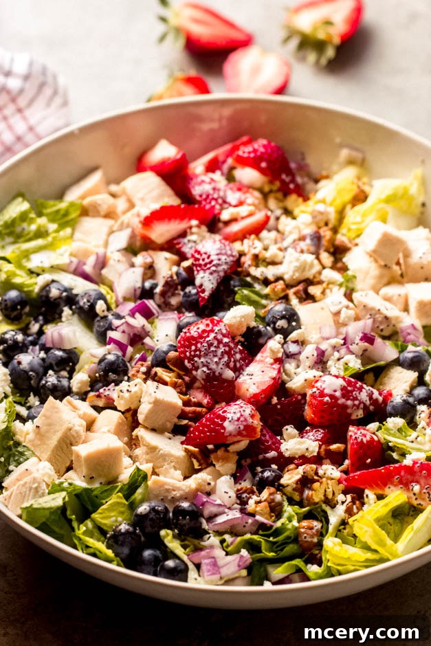 Refreshing Panera Strawberry Salad 3 Close-up of strawberry poppyseed salad featuring chicken, romaine, sweet berries, pecans, and feta.