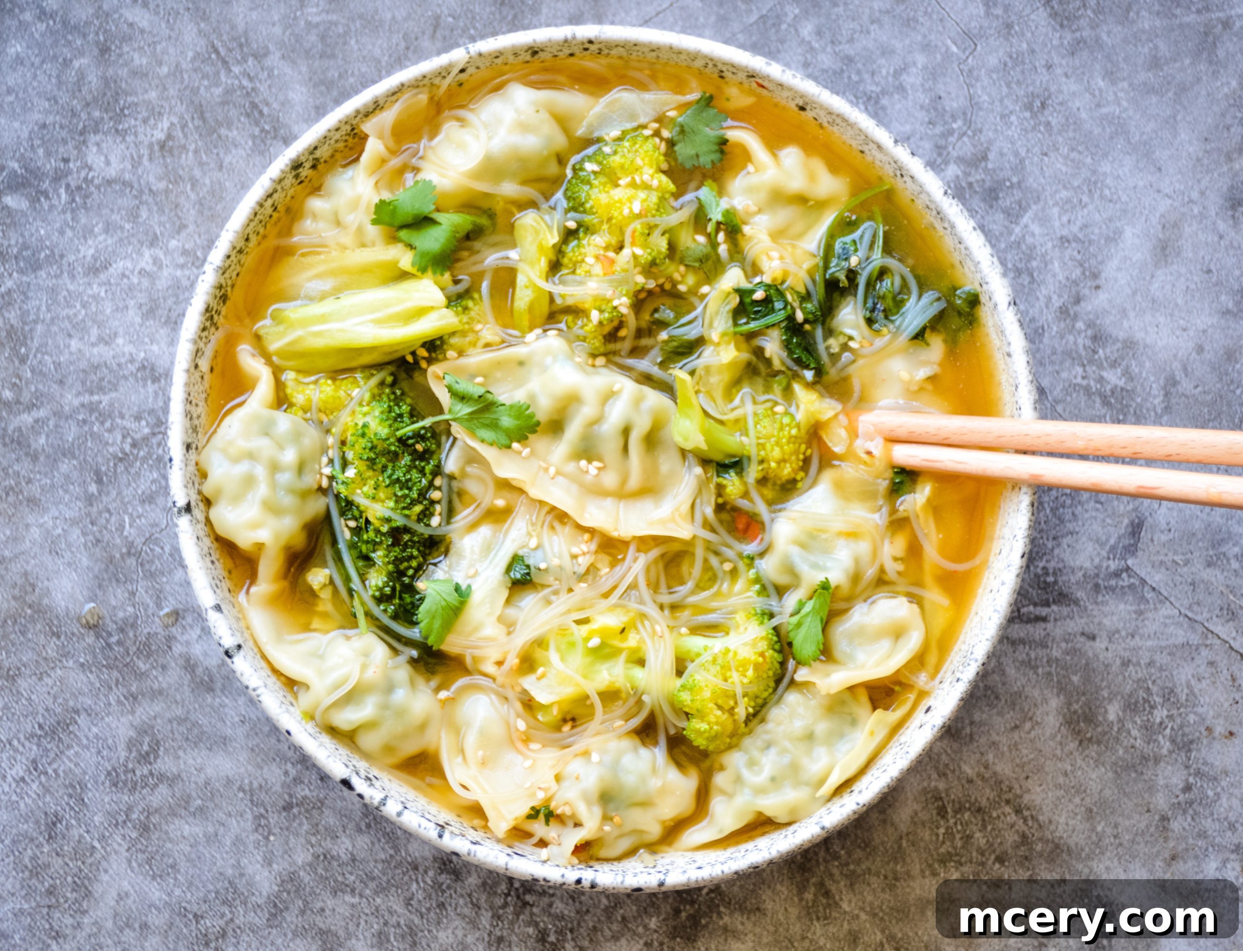 Wonton Soup In A Flash 2 A steaming bowl of Quick & Easy Wonton Soup, garnished with fresh cilantro and green onions.