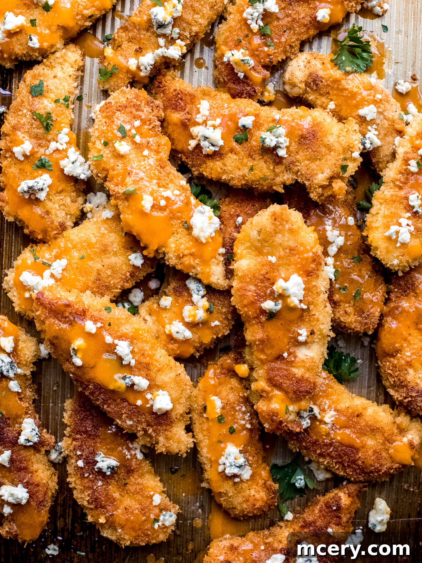 Crispy Baked Buffalo Chicken Tenders drizzled with sauce and topped with gorgonzola cheese.