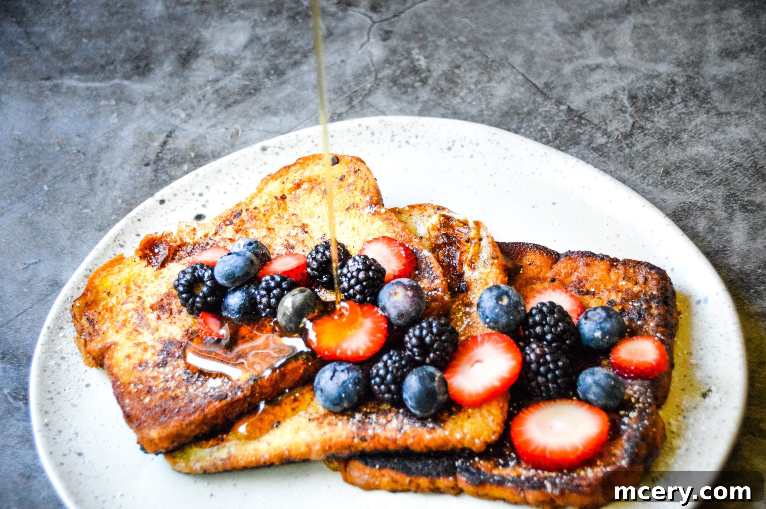 A close-up of French toast slices, golden and lightly browned, waiting to be served.