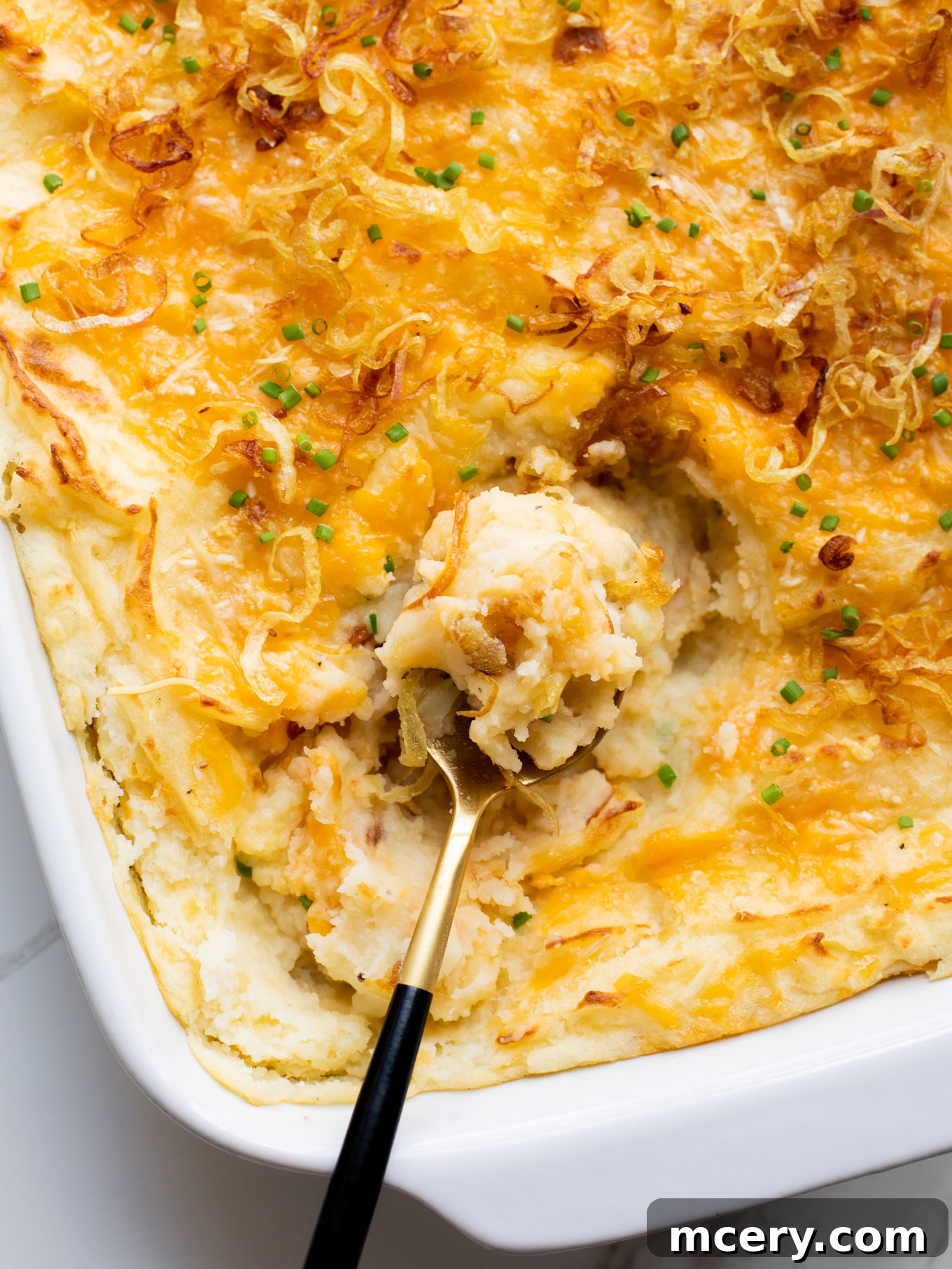 Ultimate Cheesy Baked Mash 10 cheesy mashed potato bake garnished with chives and crispy shallots
