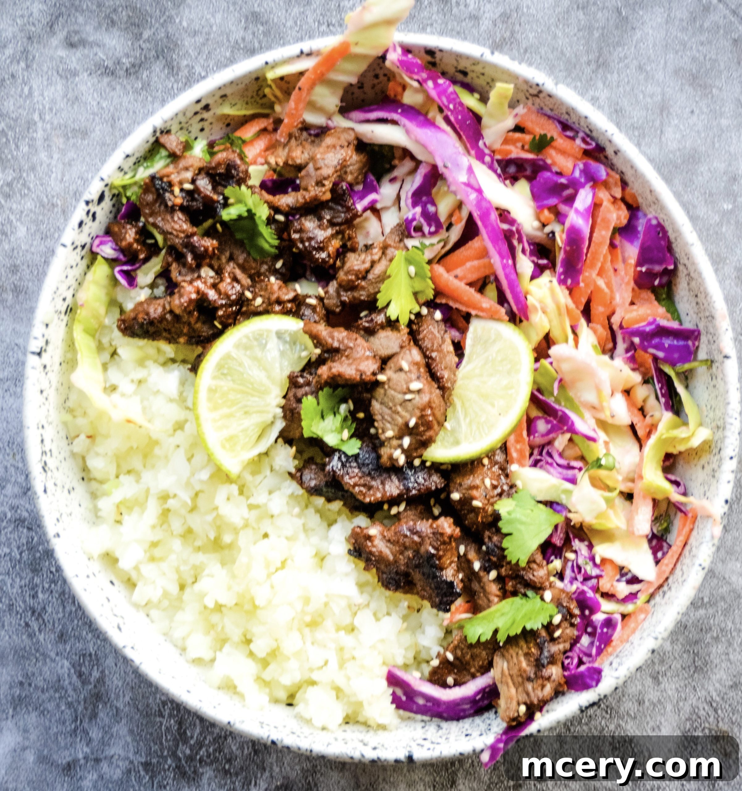 Glazed Asian Steak Bites with Zesty Slaw Bowl 2 A vibrant Asian Steak Bites and Coleslaw Bowl, featuring perfectly cooked steak bites nestled among a colorful coleslaw and rice.