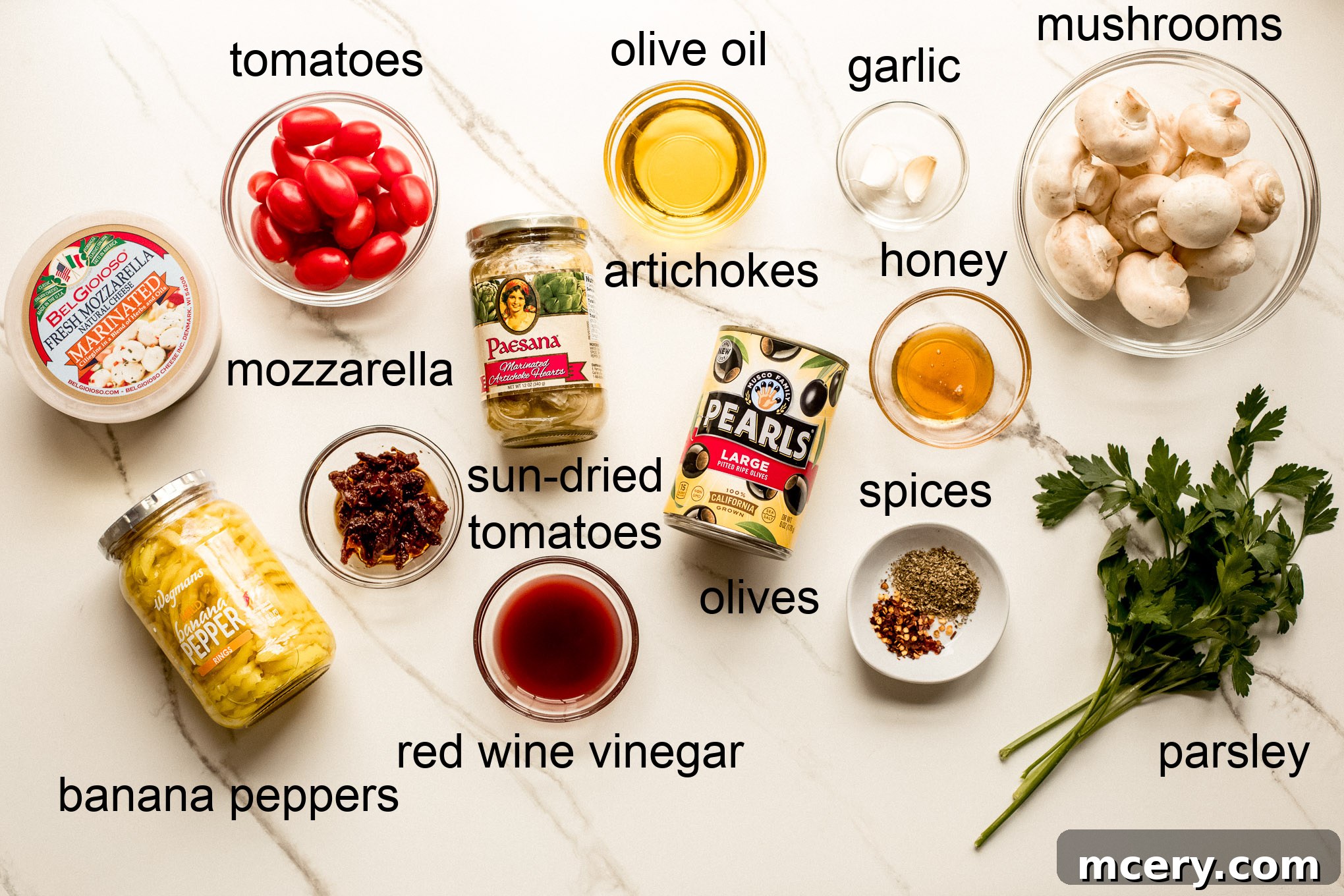 A collection of fresh and jarred ingredients ready to be assembled for the antipasto salad platter.