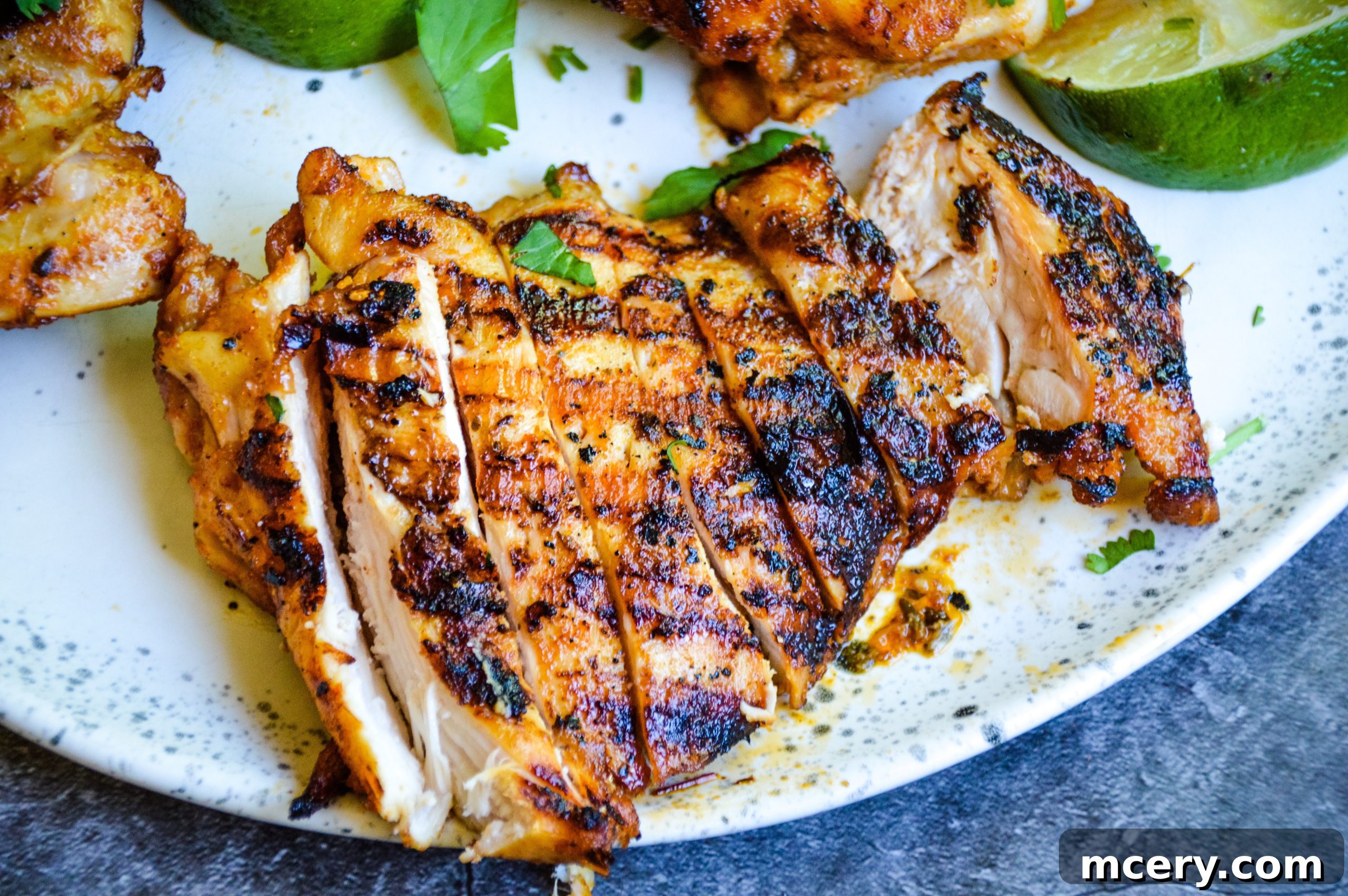 Orange Chipotle Chicken cooking on a cast iron skillet, showing a beautiful sear.