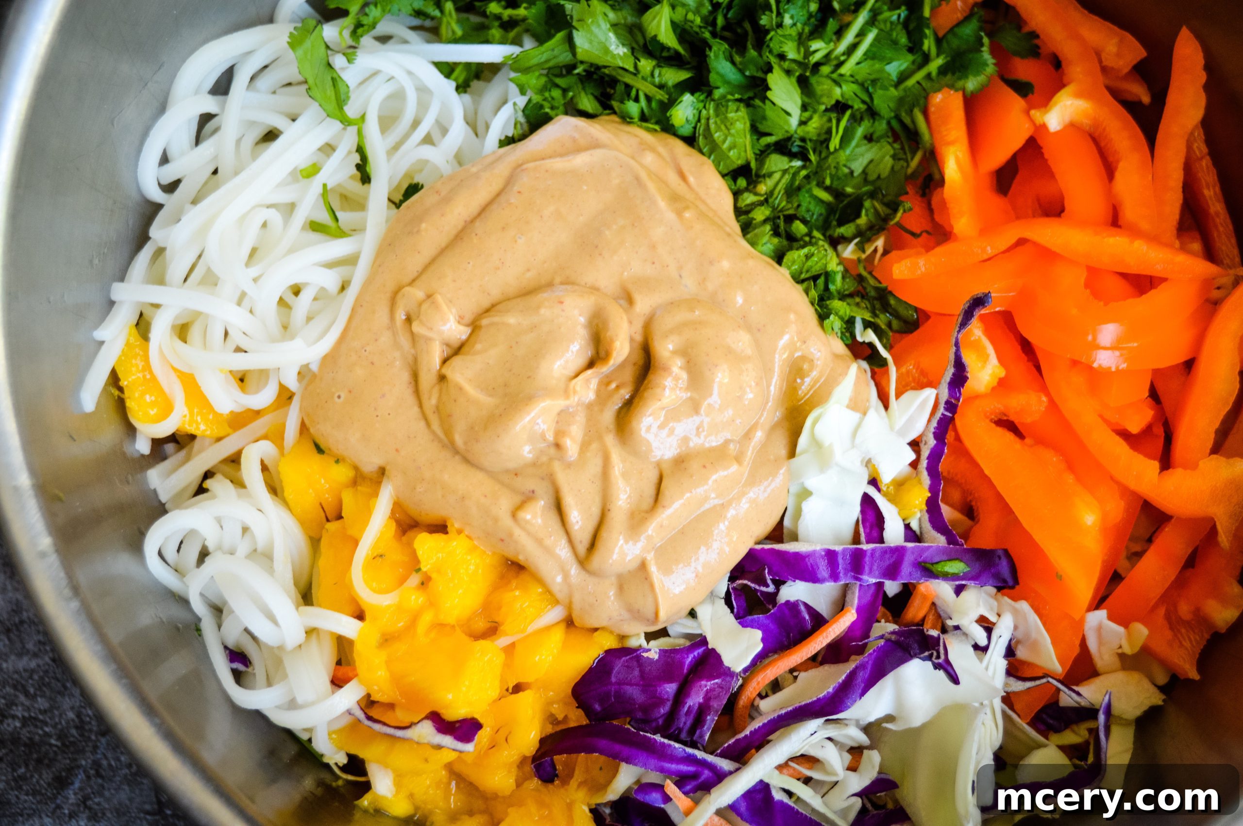 Perfectly Cooked Rice Noodles Cooked stir-fry rice noodles are shown in a bowl, perfectly prepared and ready to be combined with the fresh vegetables and peanut sauce.