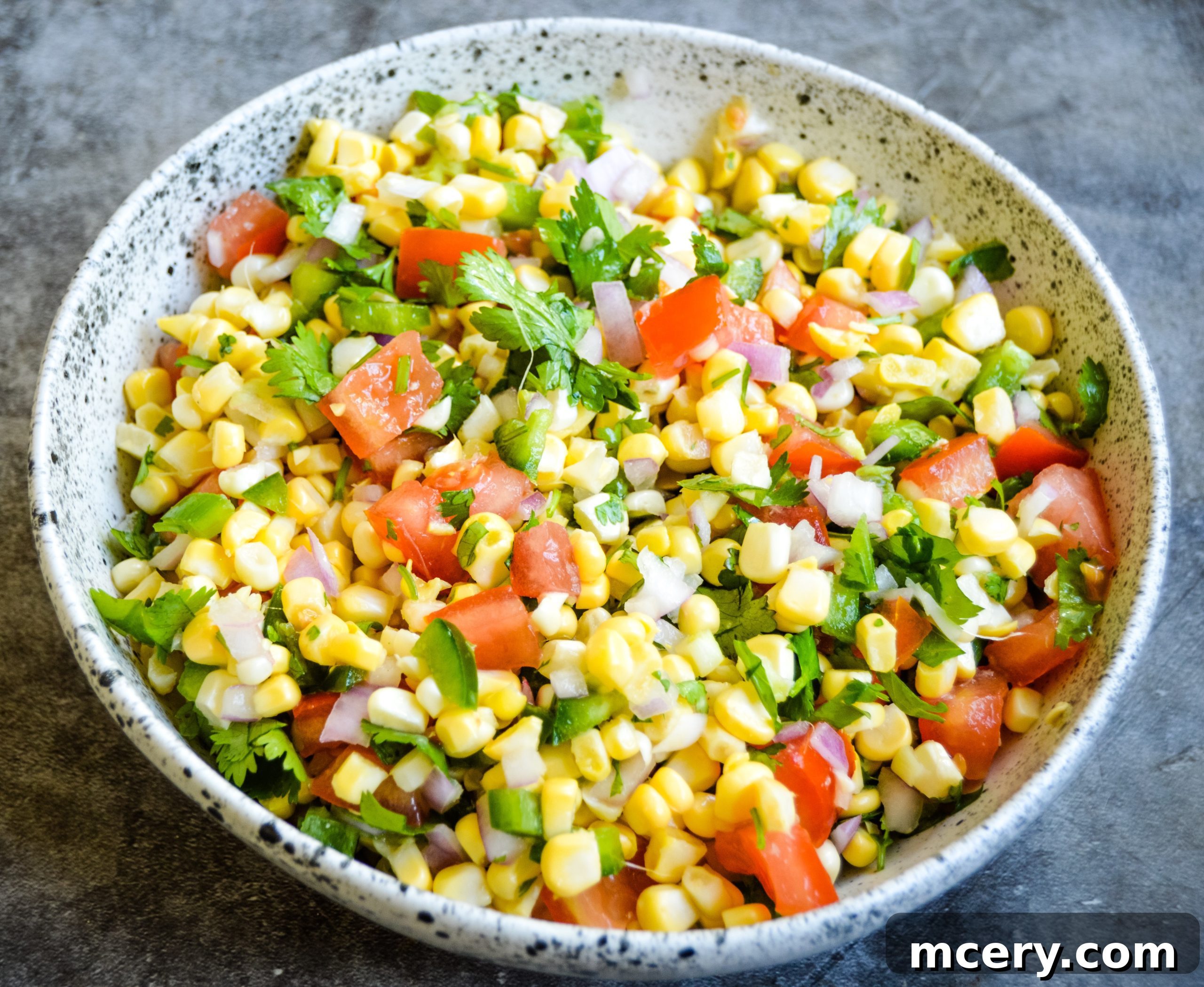 Sunshine Corn Salsa 6 Ingredients for corn salsa laid out on a cutting board, including fresh corn, red onion, jalapeño, and limes.