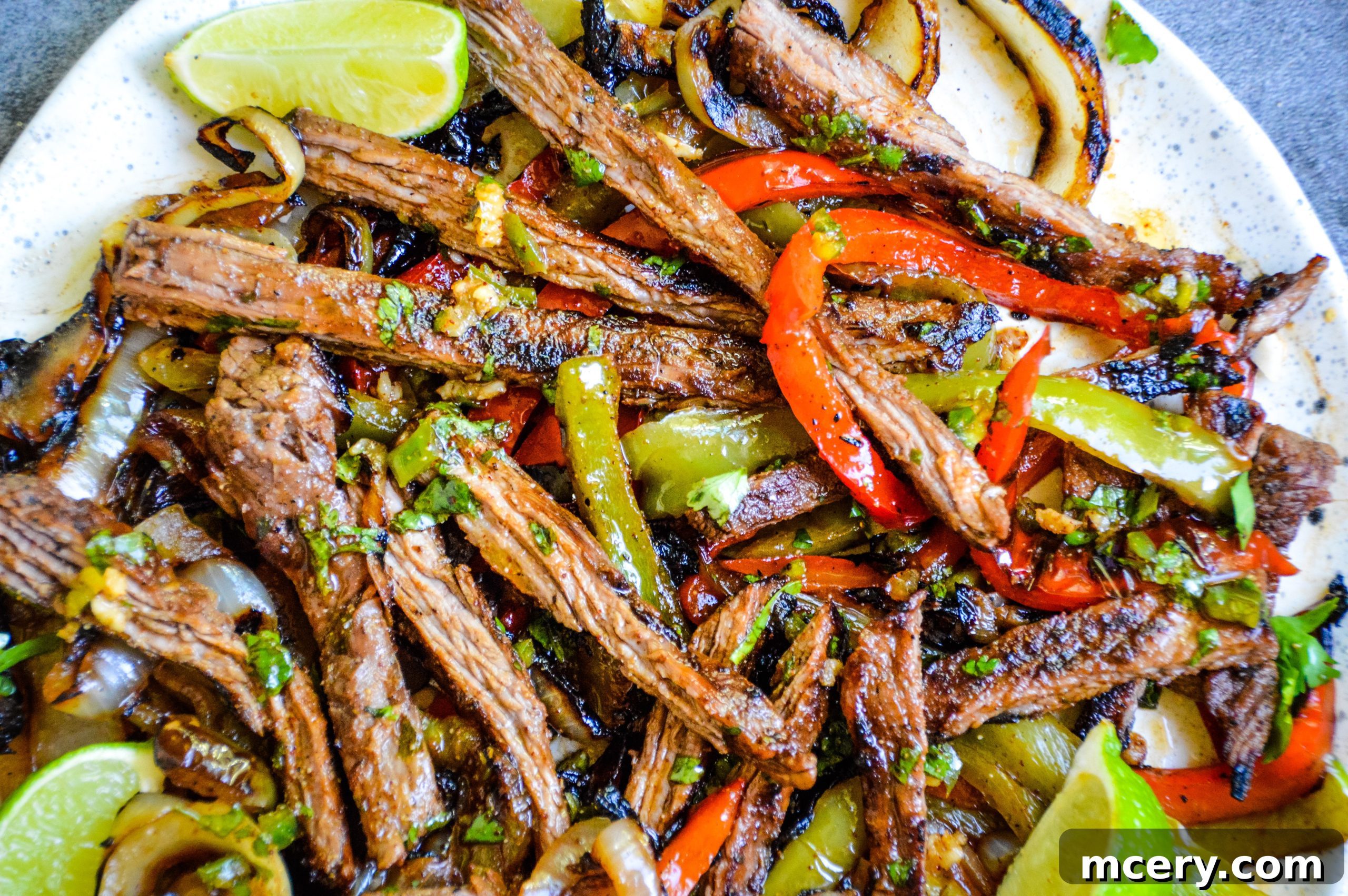 Close-up of tender steak fajita strips with caramelized onions and bell peppers.