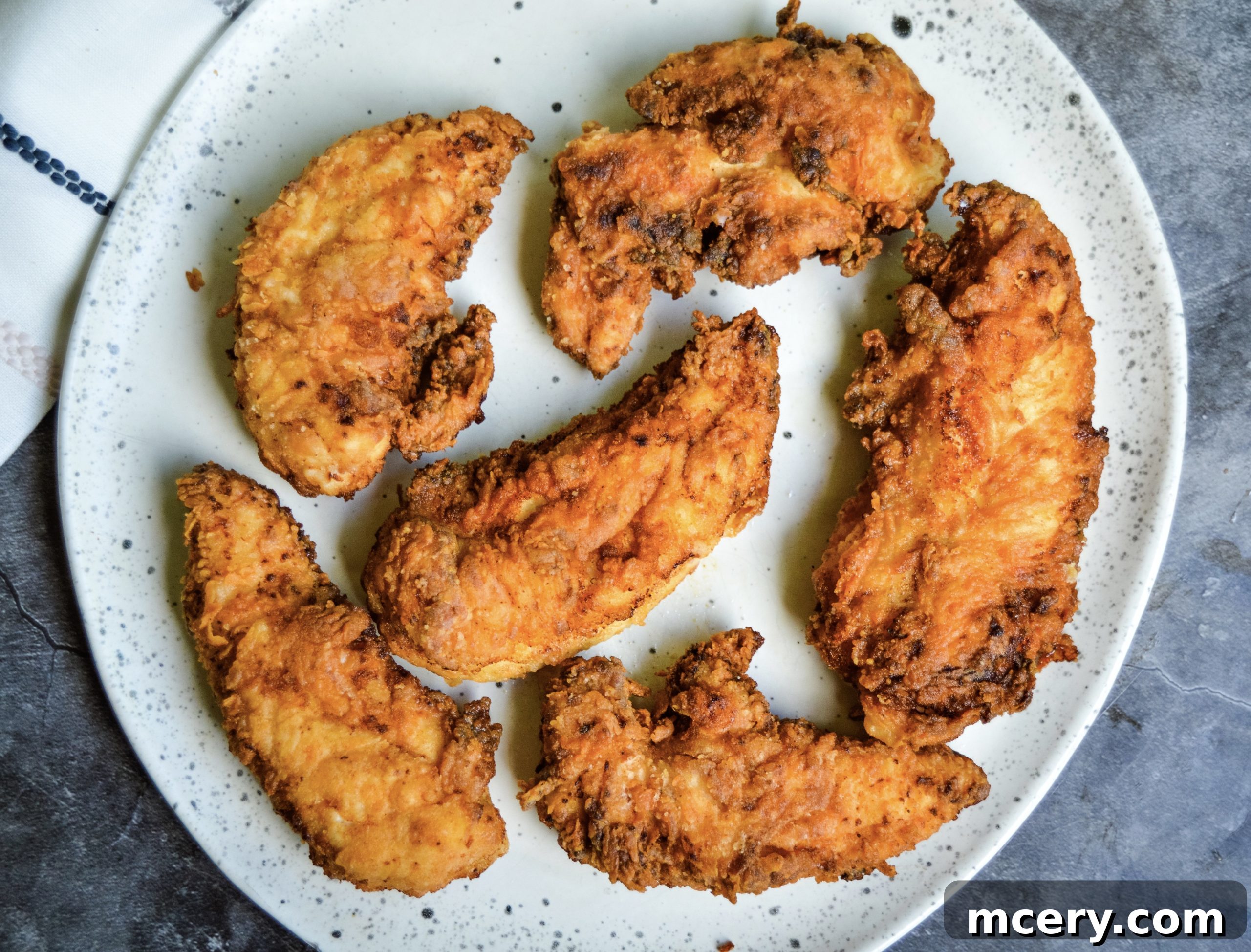 Golden Crunchy Chicken Strips 2 Golden brown crispy chicken tenders on a plate, ready to be served.