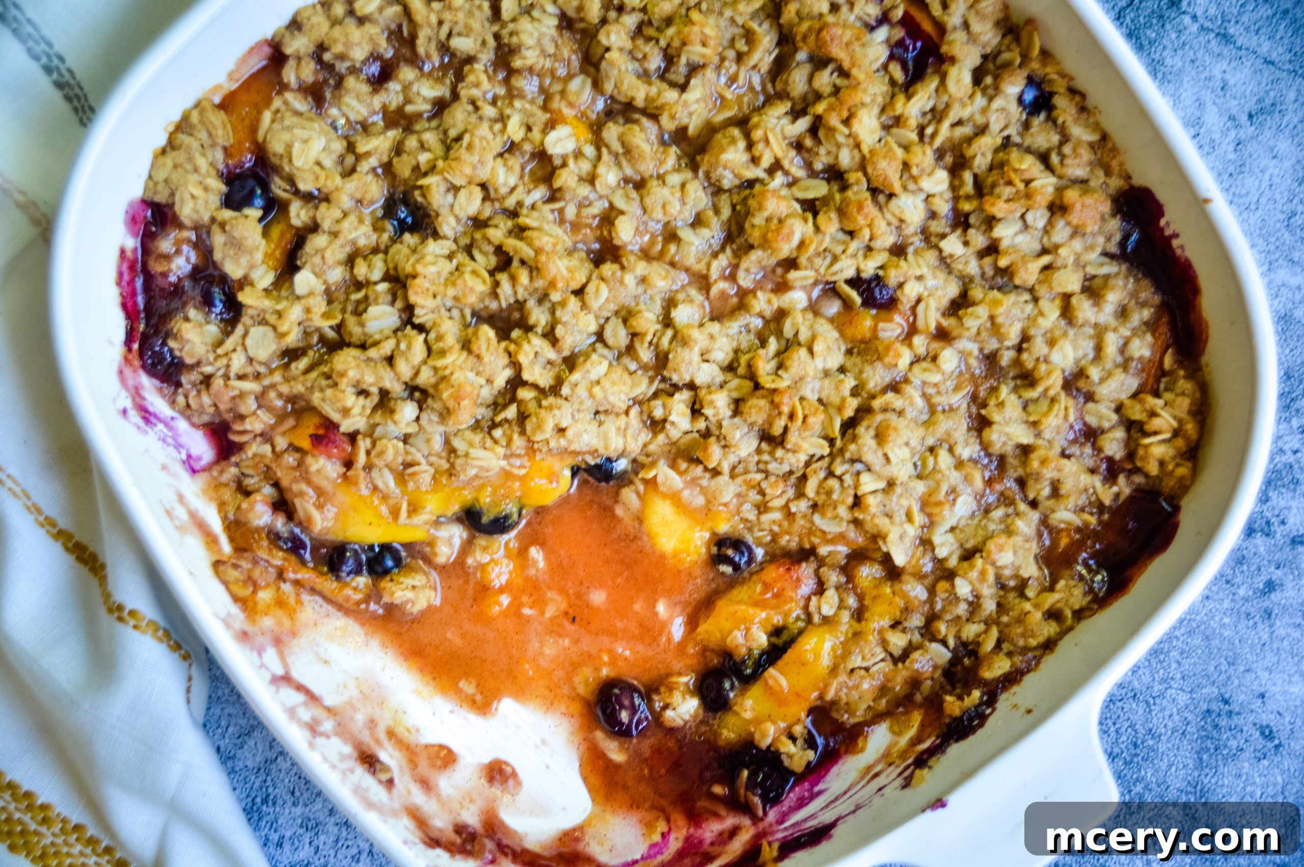 Sunshine Peach Blueberry Crisp 4 A serving of Peach Blueberry Crisp with a scoop of melting vanilla ice cream.