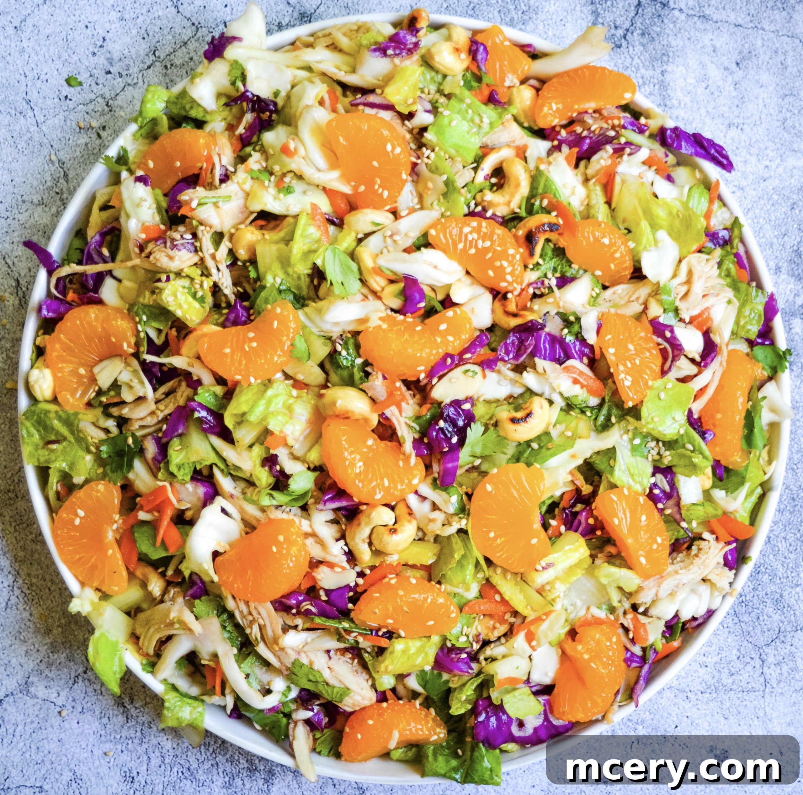 A vibrant, healthy Chinese Chicken Chopped Salad in a large serving bowl, brimming with fresh vegetables, chicken, and a zesty dressing.