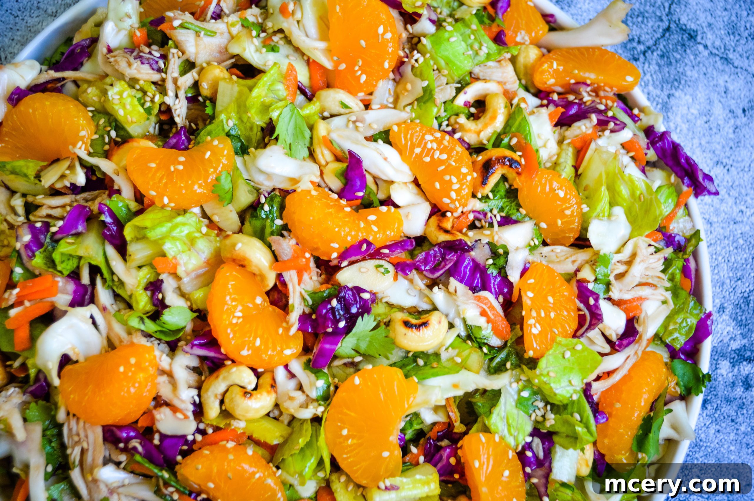 A close-up shot of a single serving of Chinese Chicken Chopped Salad on a white plate, ready to be enjoyed, highlighting its fresh appeal.