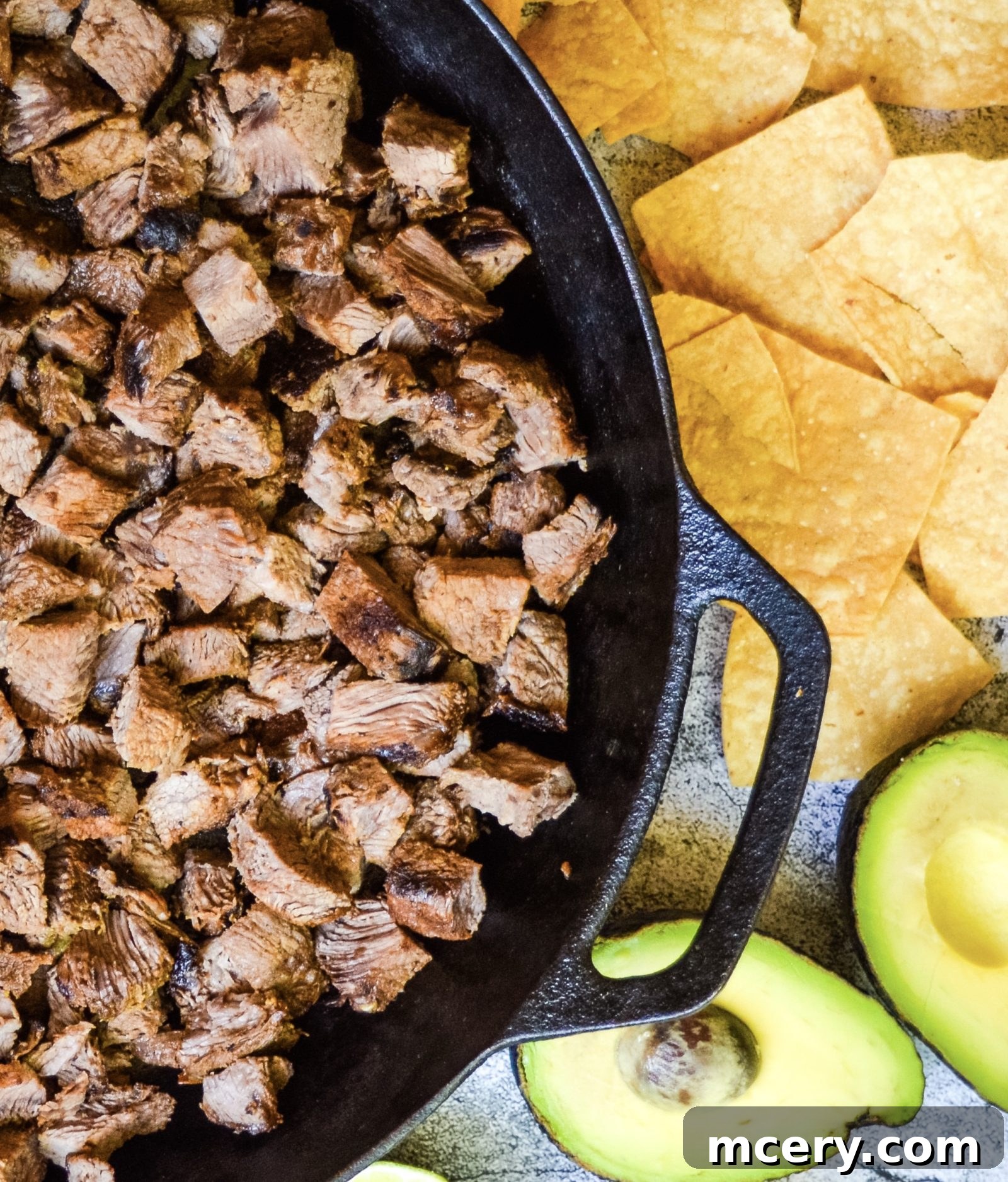 Loaded Carne Asada Nachos 3 Close-up of a perfectly grilled and sliced Carne Asada steak, showing its tender interior and charred edges, ready to be added to nachos.