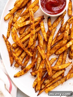 old bay fries on white platter with side of ketchup.