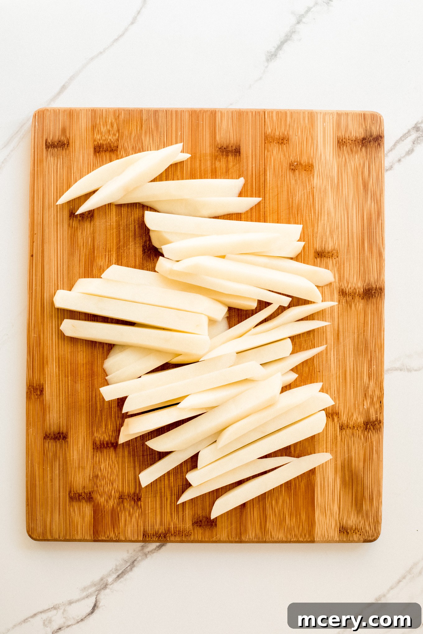 Signature Old Bay Fries 4 cut up potatoes on a cutting board.