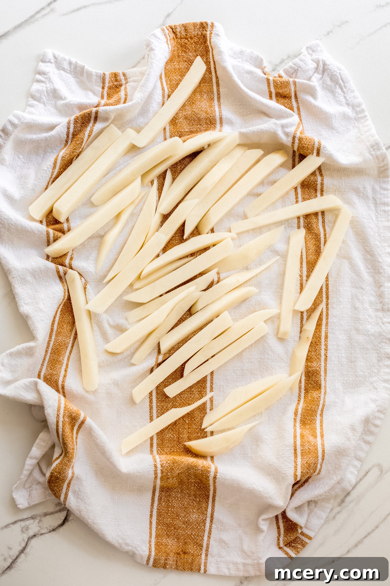 Signature Old Bay Fries 6 cut up potatoes drying on a towel.