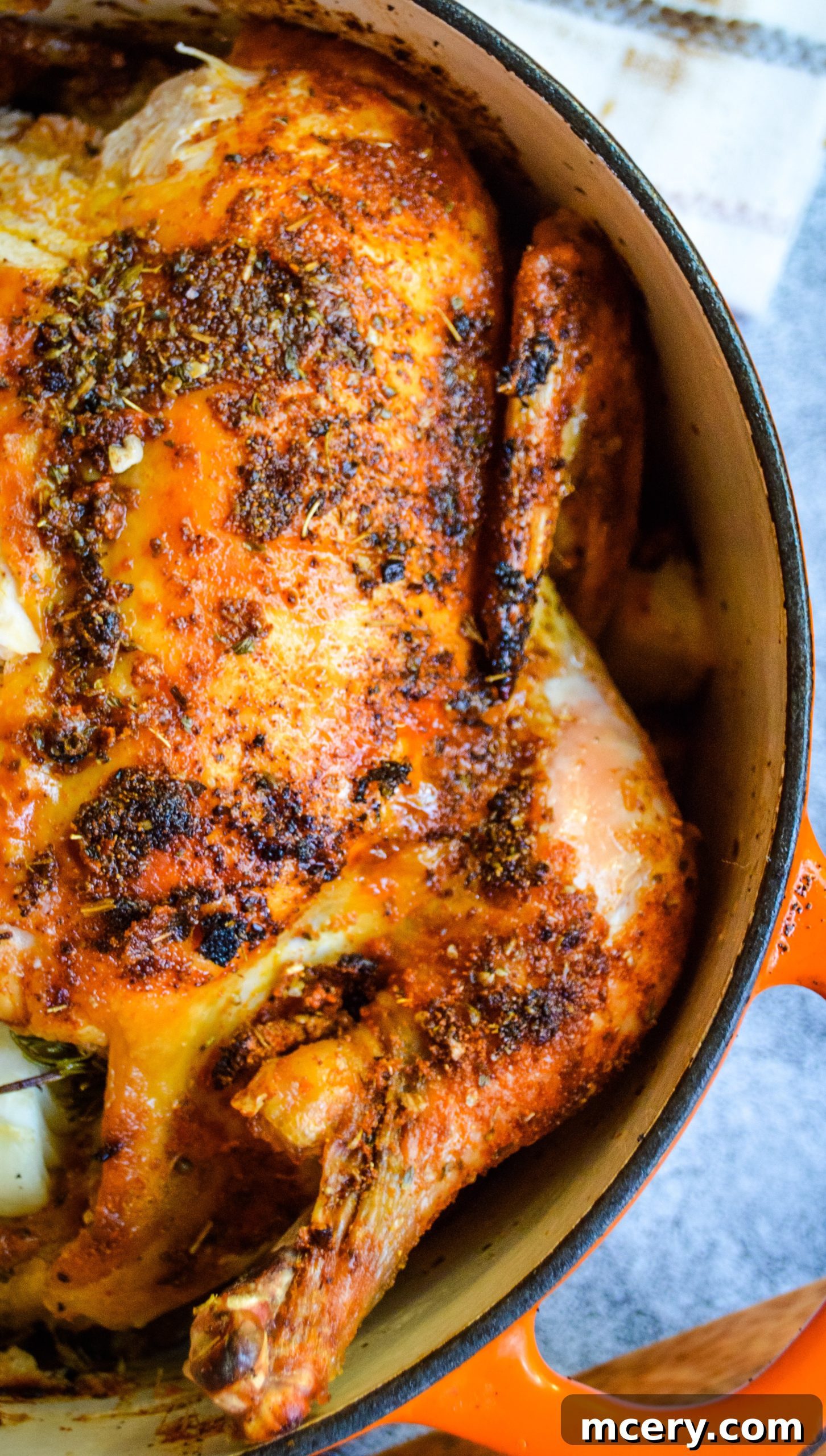 Golden brown roasted chicken with crispy skin, seasoned with herbs, resting on a cutting board, ready to be carved.
