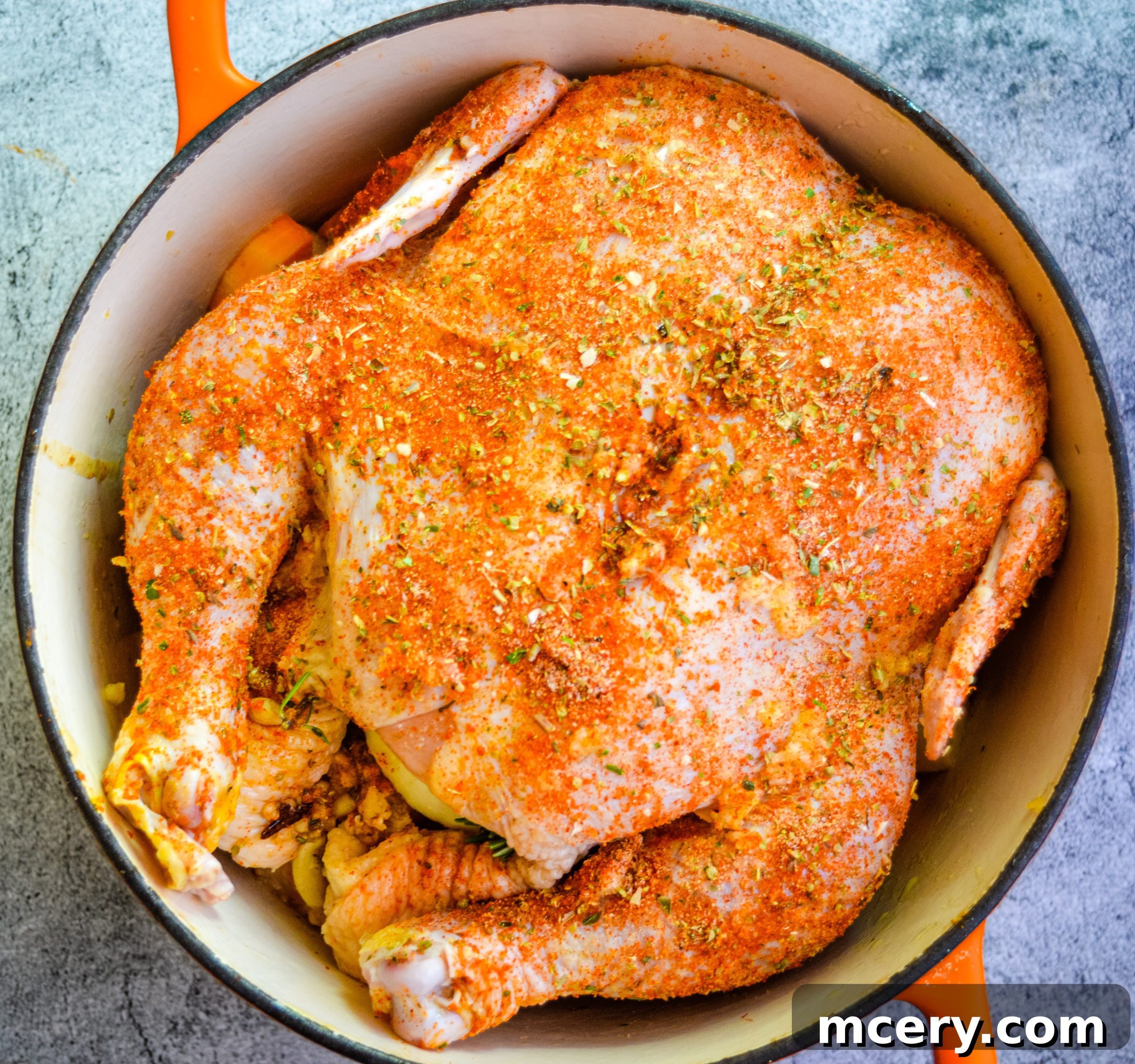 A whole roasted chicken, golden and crispy, just removed from the oven and resting in a large roasting pan with tender vegetables.