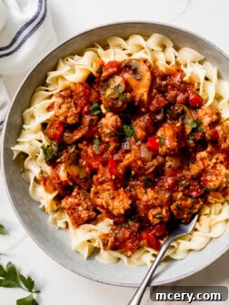 sausage cacciatore over cooked egg noodles.