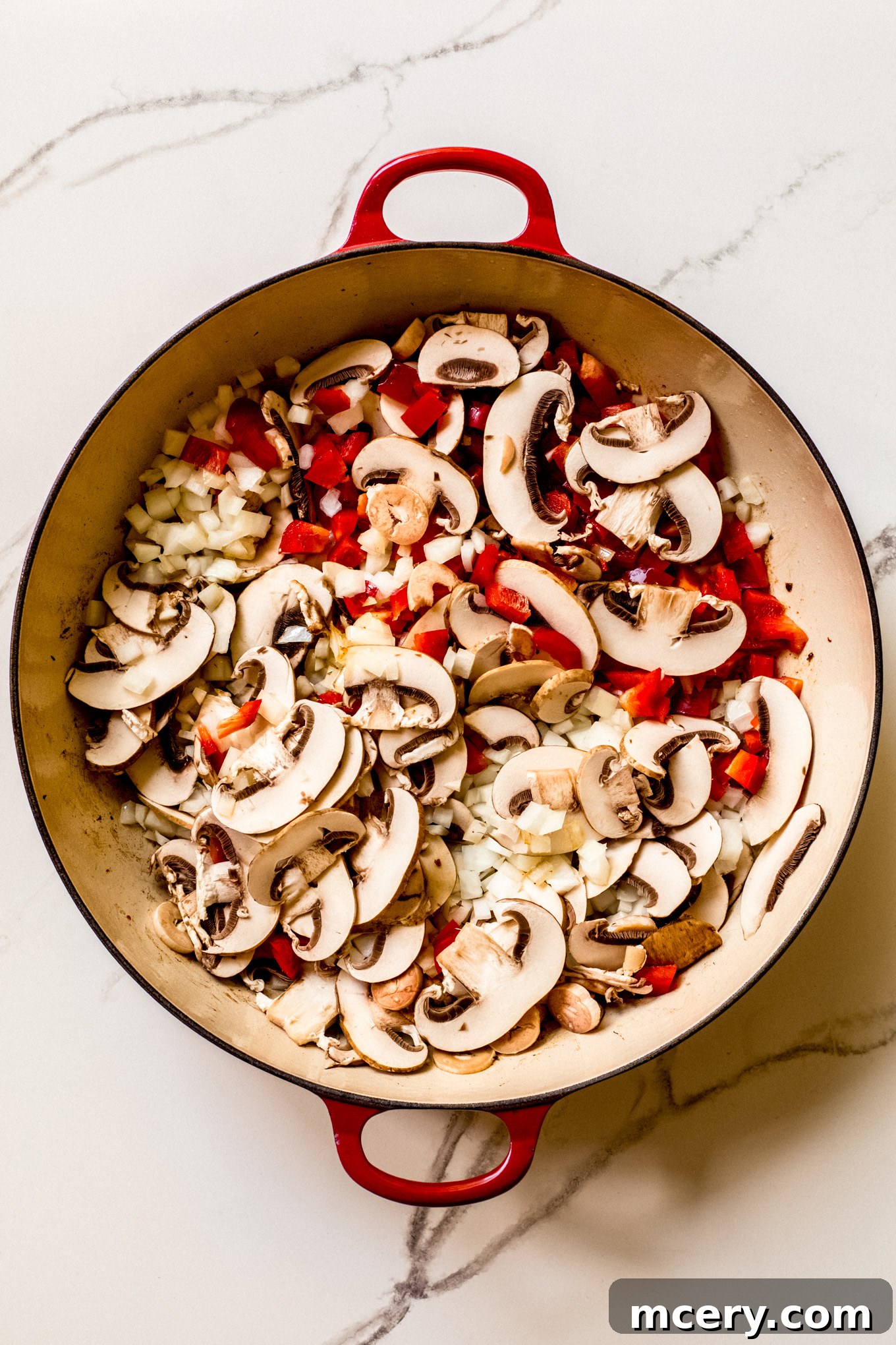 Hearty Italian Sausage and Pepper Skillet 5 sliced mushrooms, onions, and bell peppers in a saute pan.