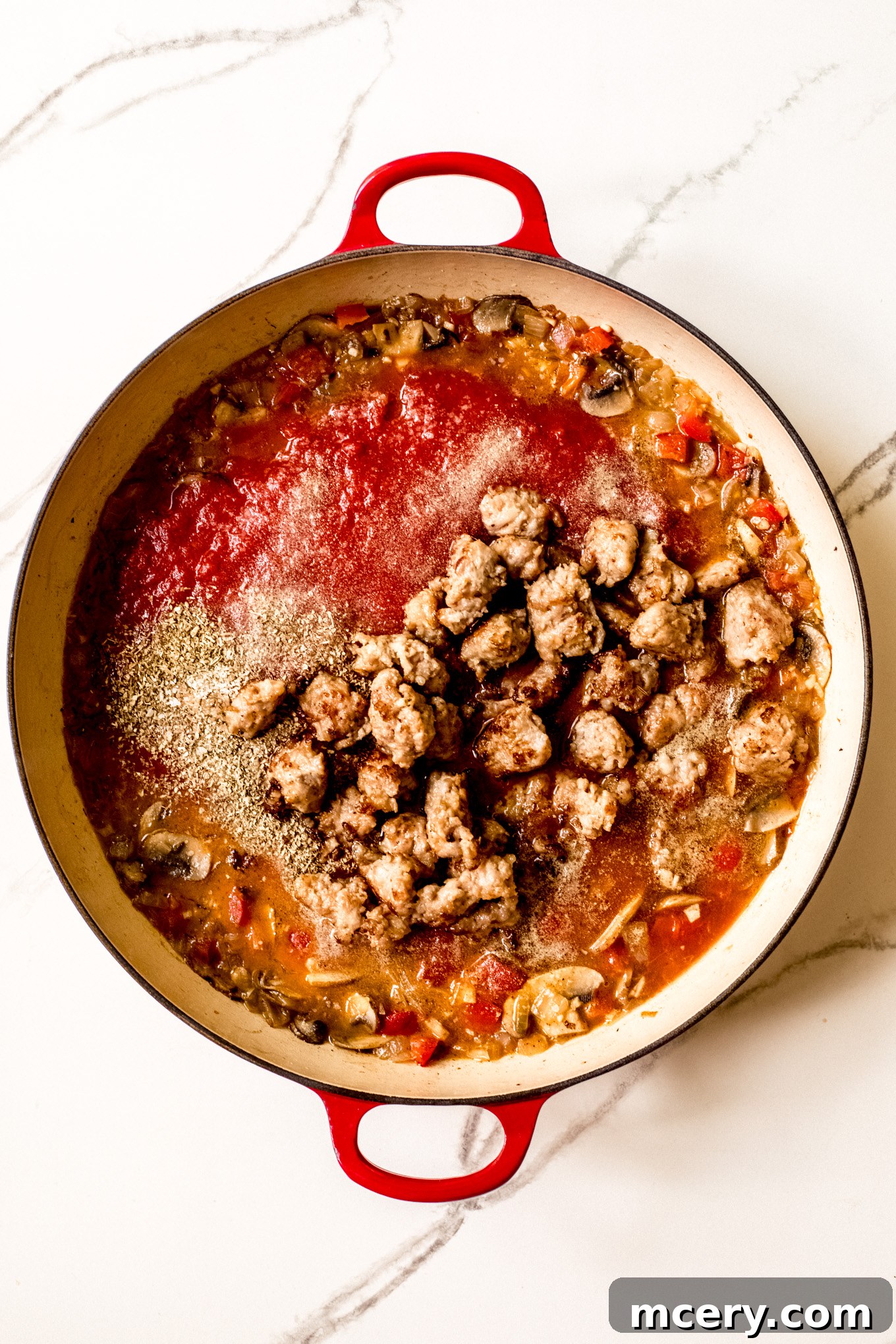 Hearty Italian Sausage and Pepper Skillet 8 tomato sauce with cooked sausage in a pan.