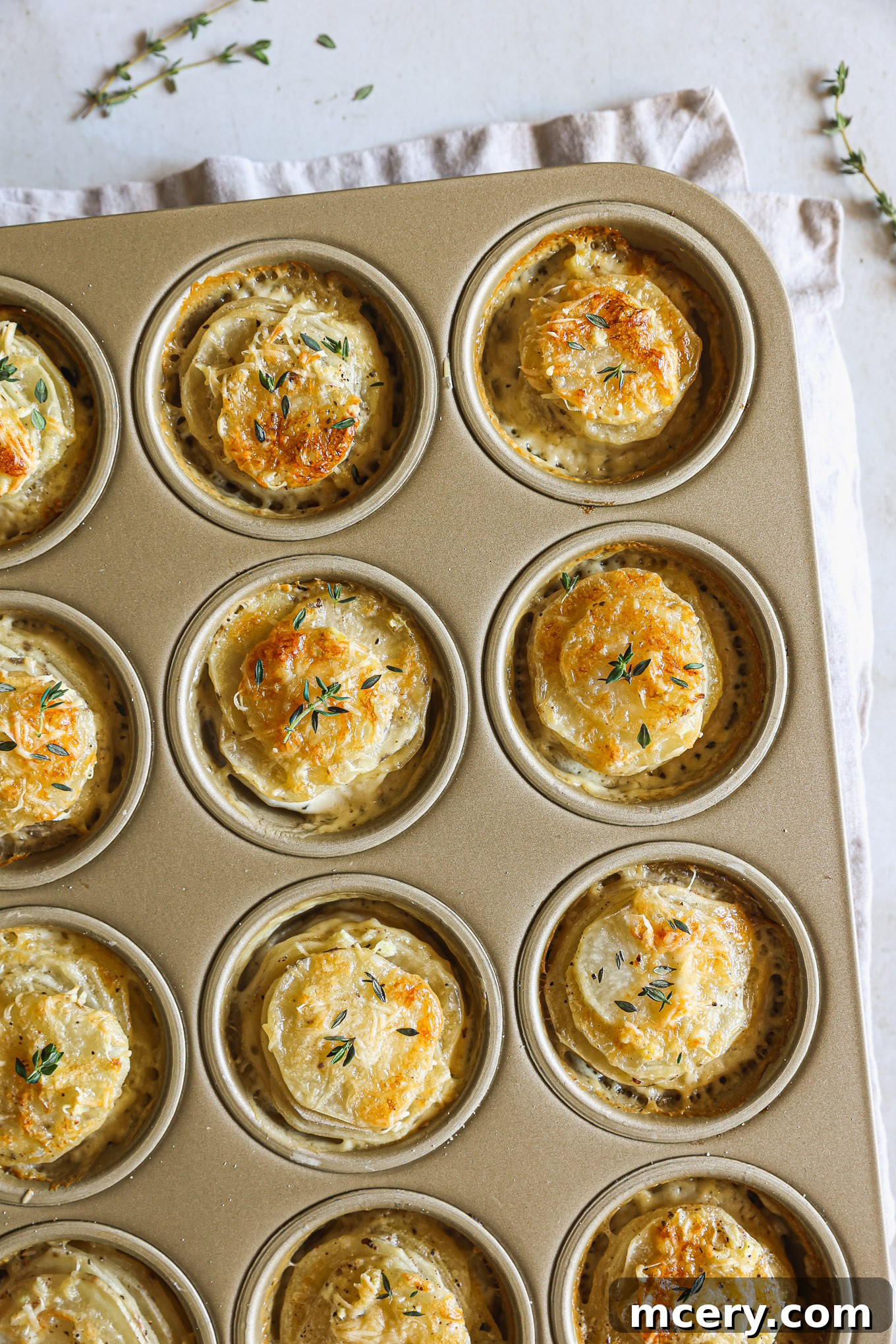 Beautifully baked potato stacks presented in a muffin pan, golden and ready to serve.