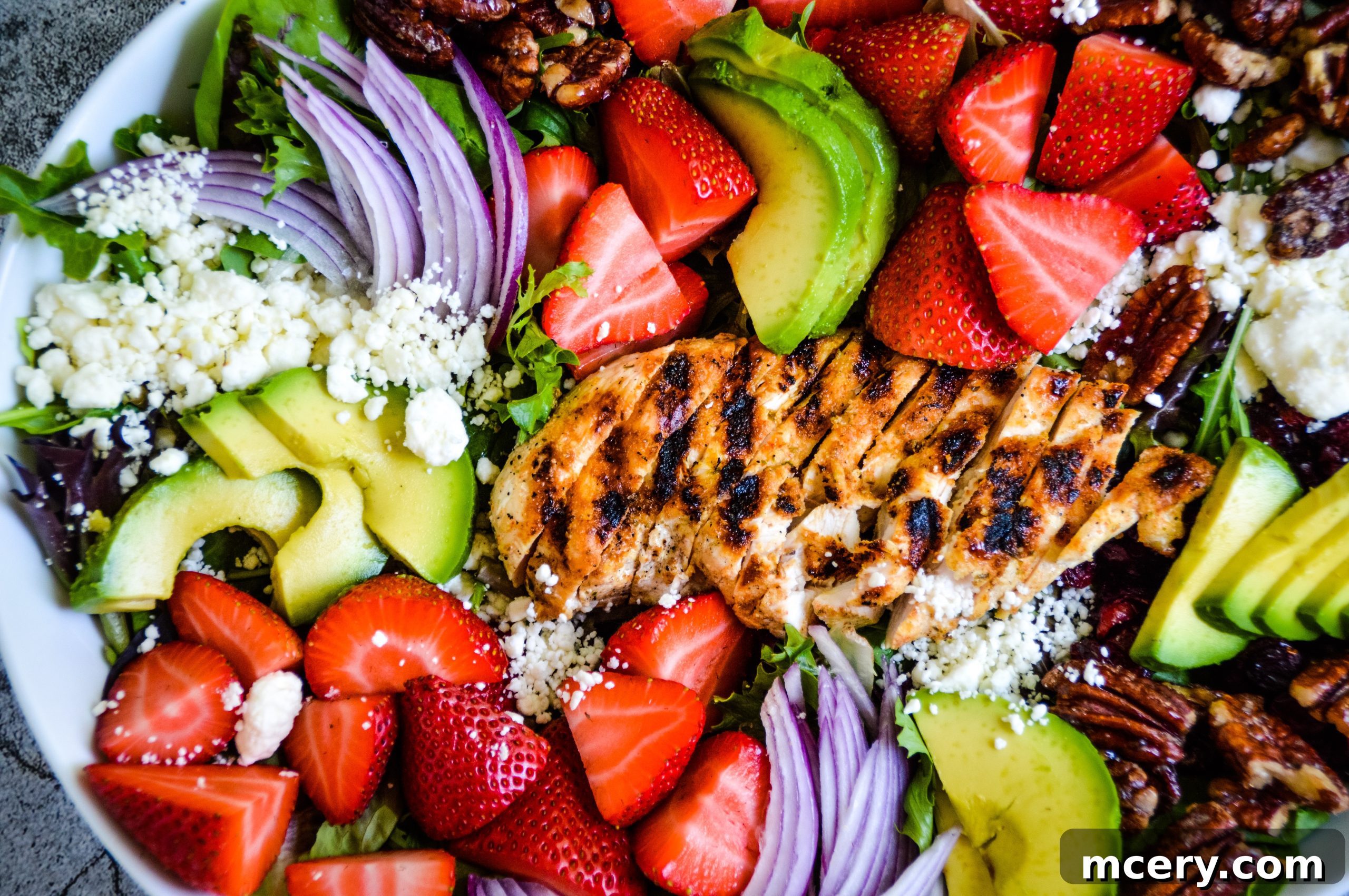 Close-up of fresh strawberries and mixed greens, ready for salad assembly.