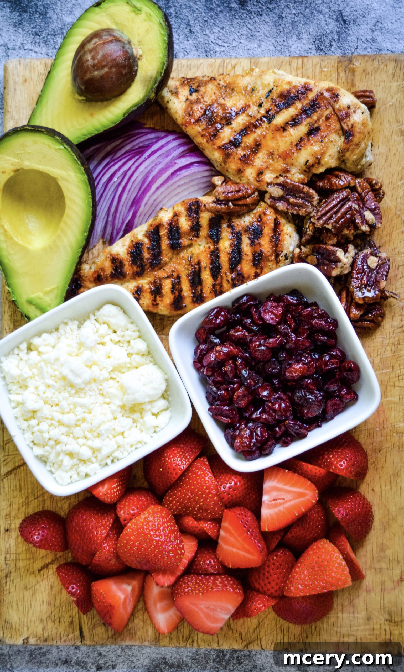 Fresh ingredients for Strawberry Fields Salad, including sliced red onion and feta cheese.