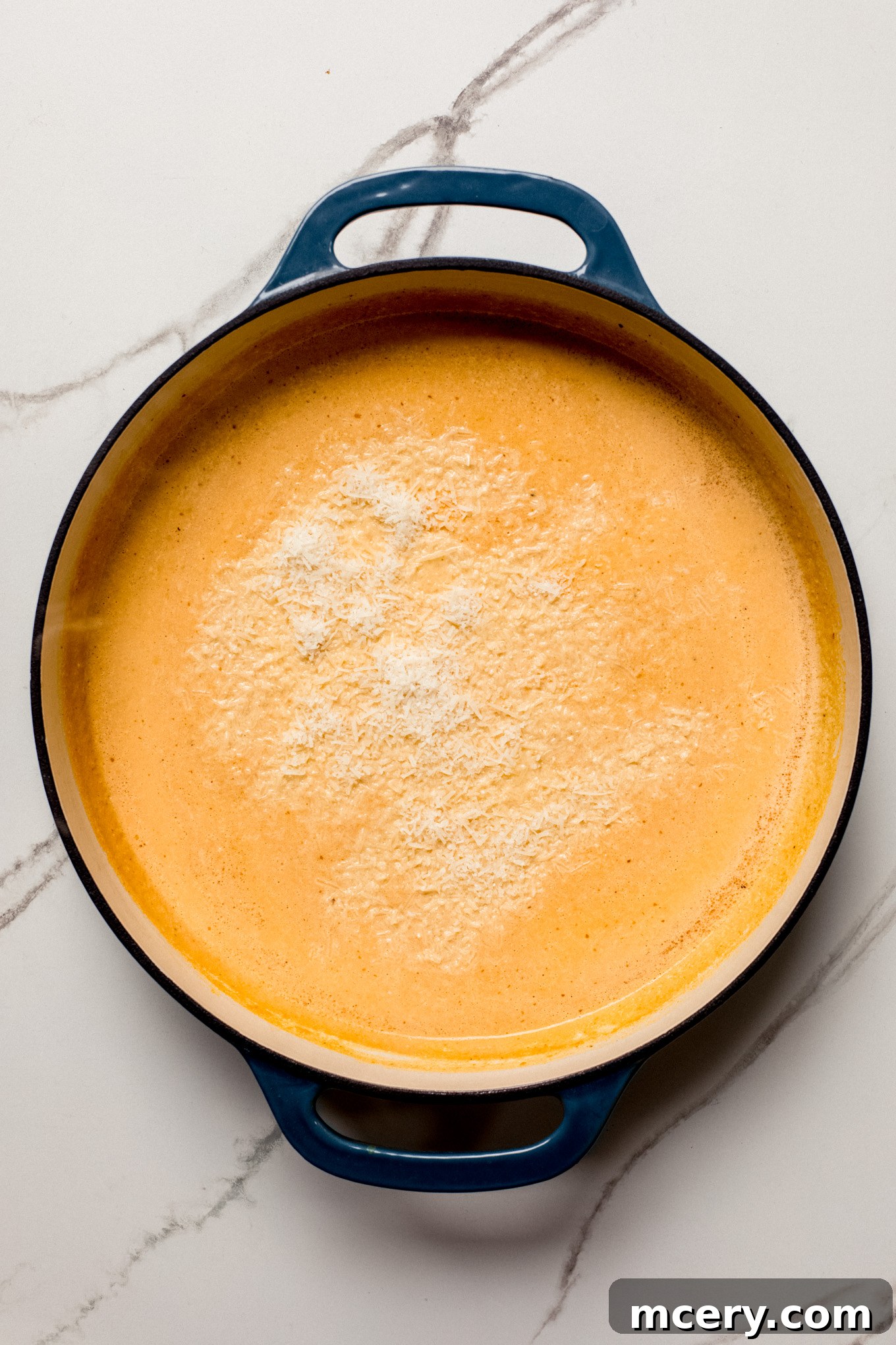 pumpkin sauce in a skillet with parmesan cheese.