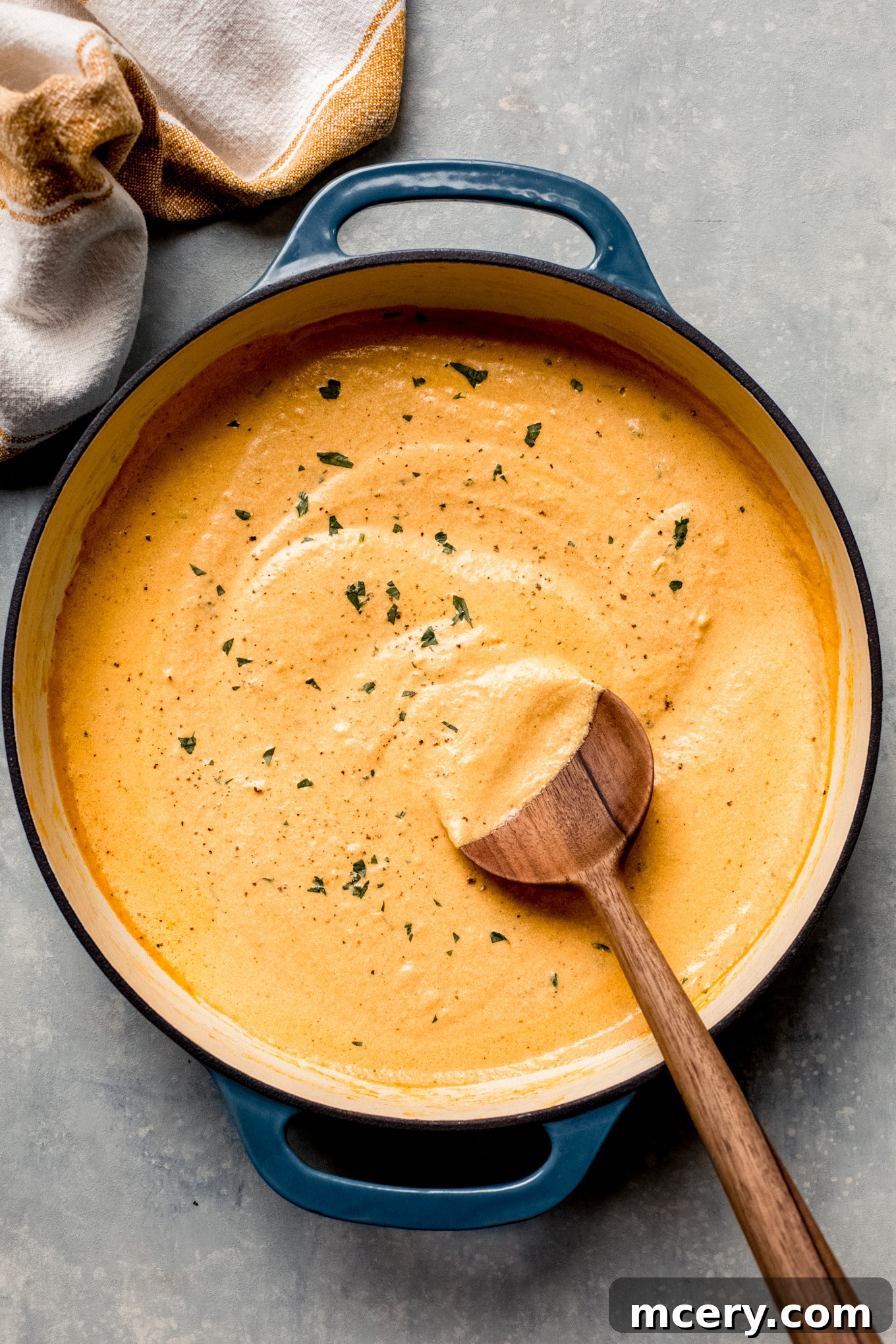 pumpkin cream sauce in a skillet with wooden spoon on the side.