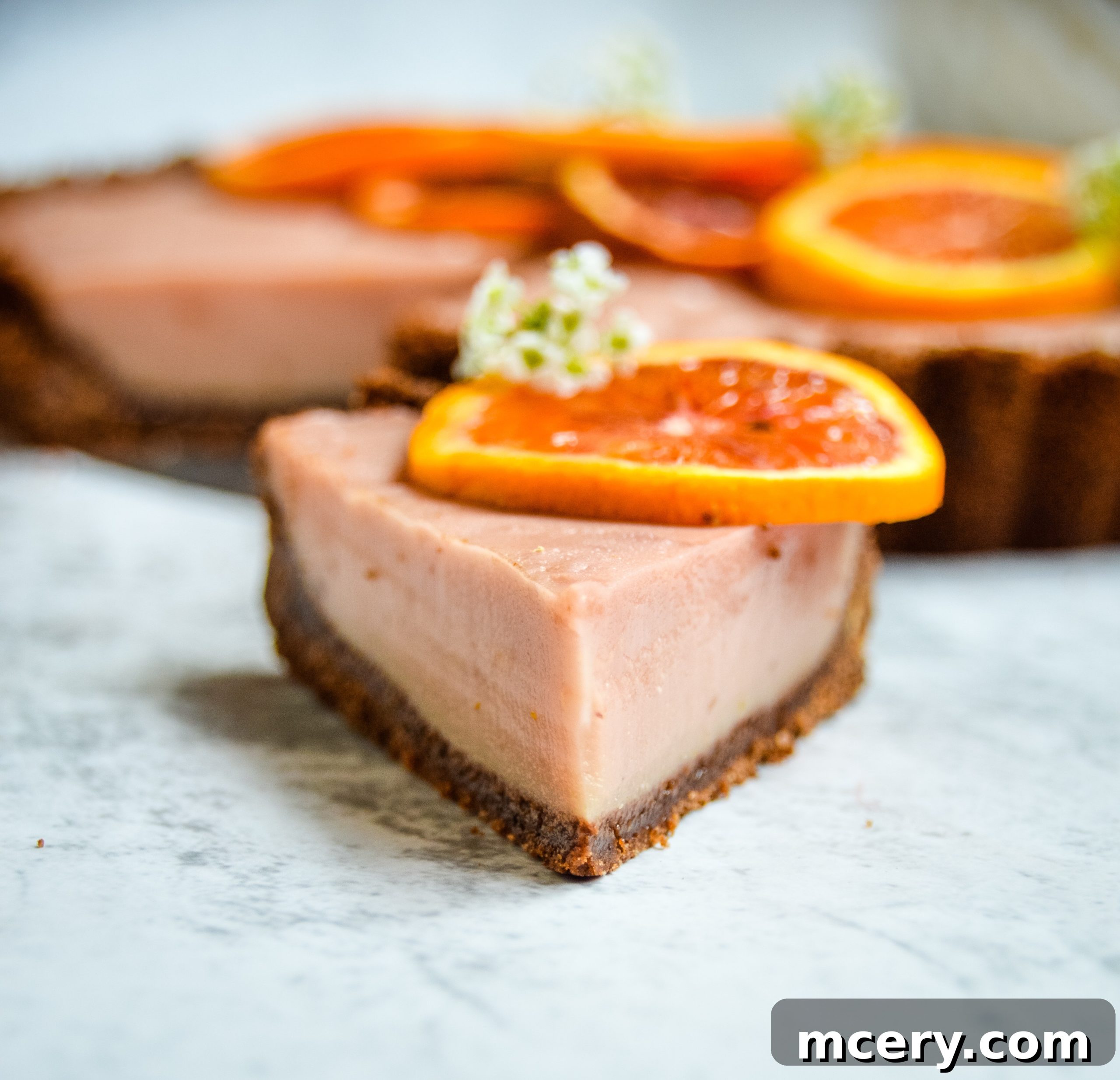 Zesty Blood Orange Tart 4 An overhead shot of the complete blood orange tart, artfully garnished with fresh blood orange slices and delicate mint leaves, ready to be served.