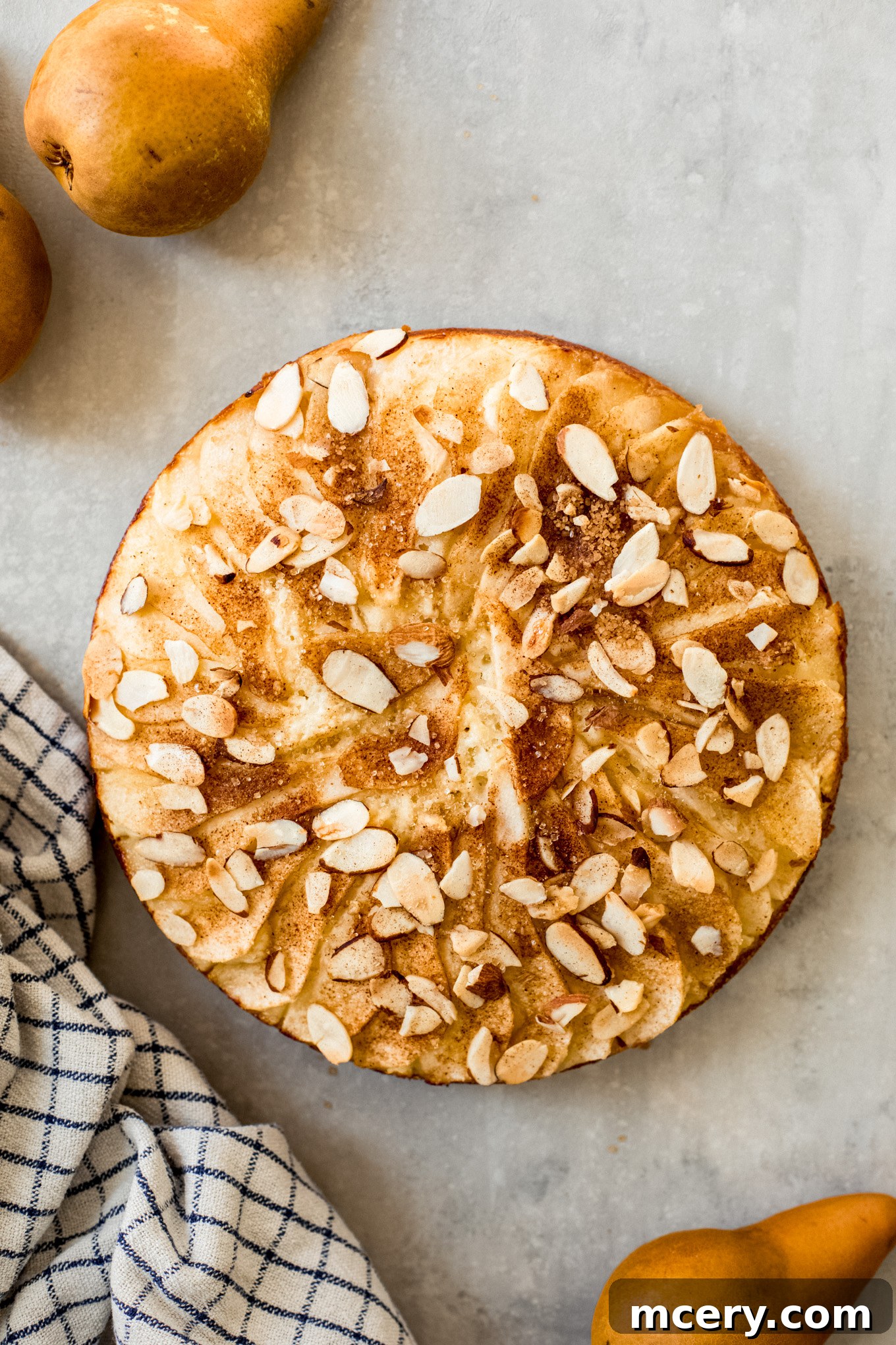Golden Pear Cake 2 Delicious pear cake with sliced almonds and a sprinkle of cinnamon sugar topping, ready to be served.