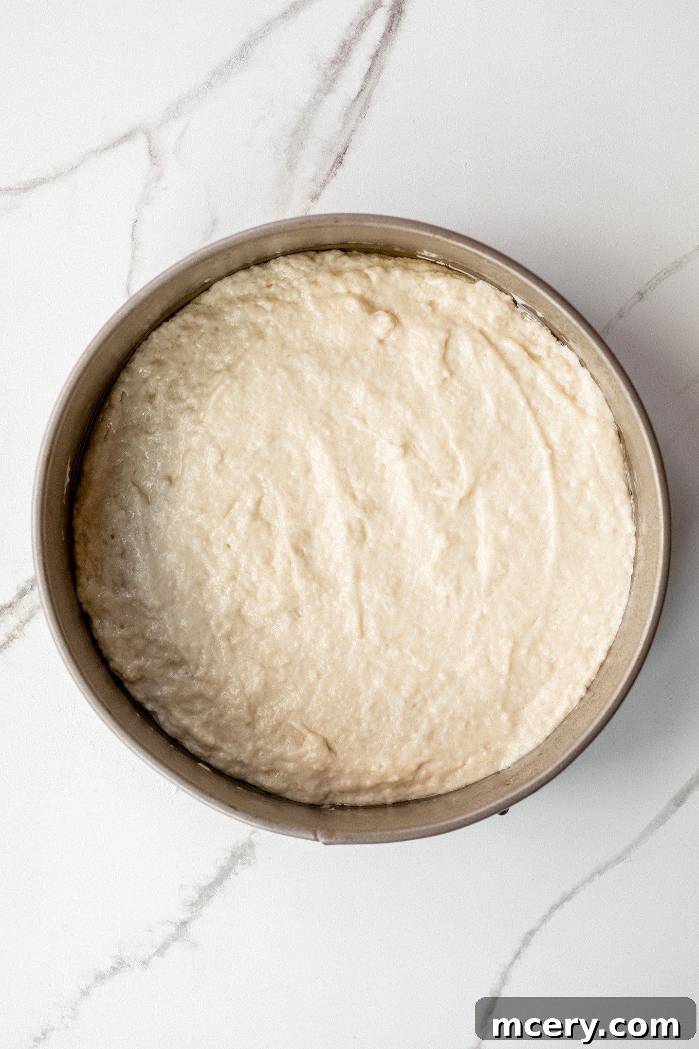 Golden Pear Cake 7 Thick cake batter poured into a greased 9-inch springform pan, ready for the next step.