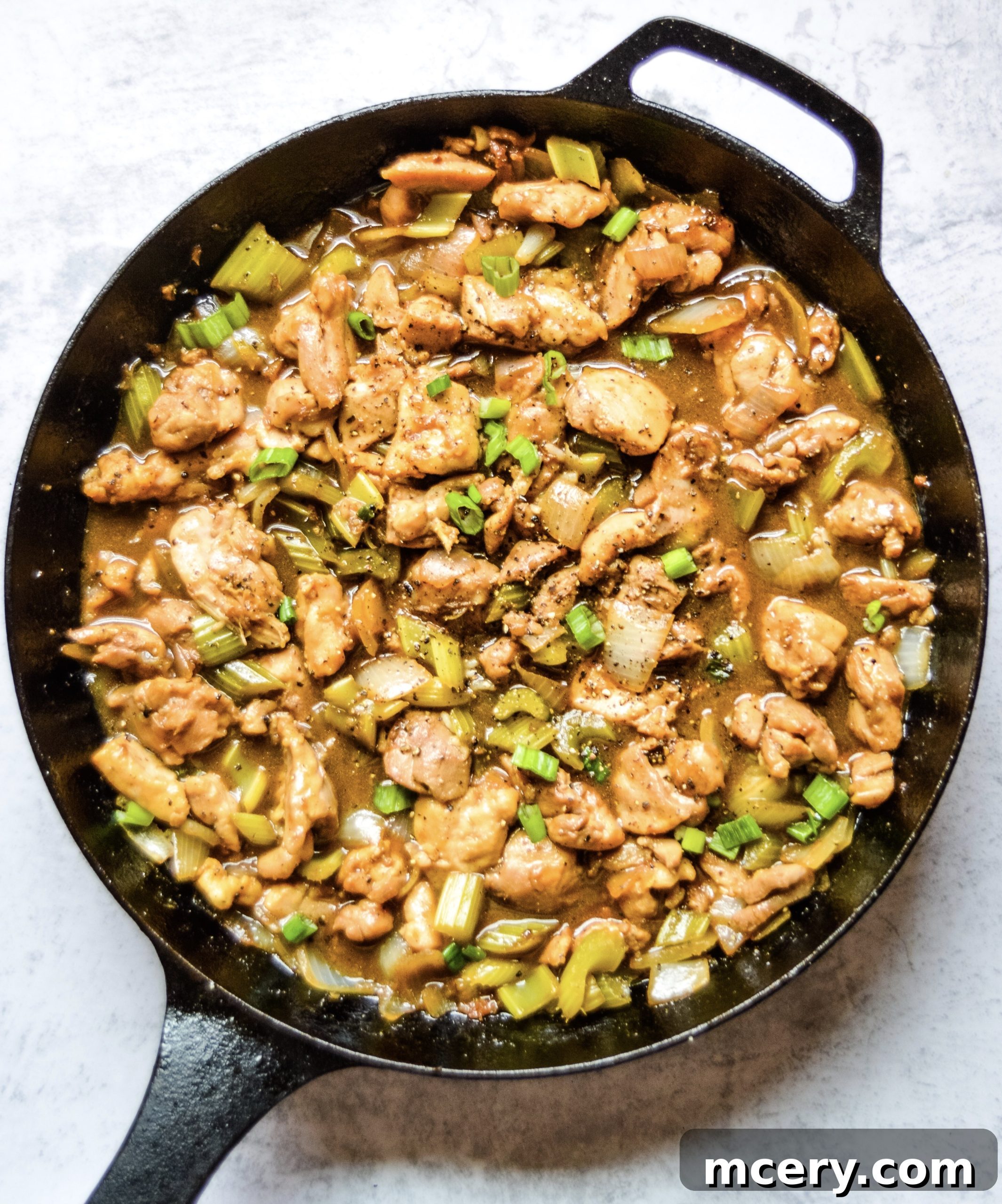 Delicious Black Pepper Chicken stir-fry, featuring crispy chicken pieces, diced celery, and onions, garnished with fresh green onions.