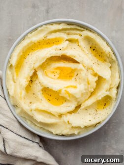 Yukon Gold mashed potatoes in a bowl with melted butter over the top.