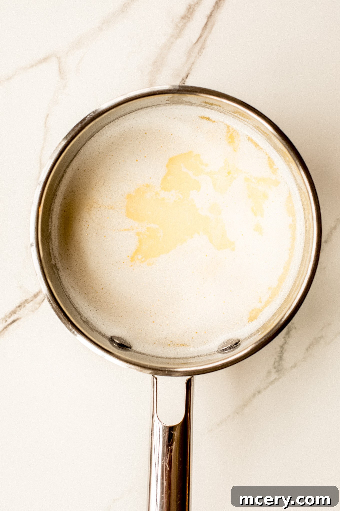 Silky Yukon Gold Mash 7 Milk with melted butter in a saucepan, gently heated and ready to be added to the potatoes.