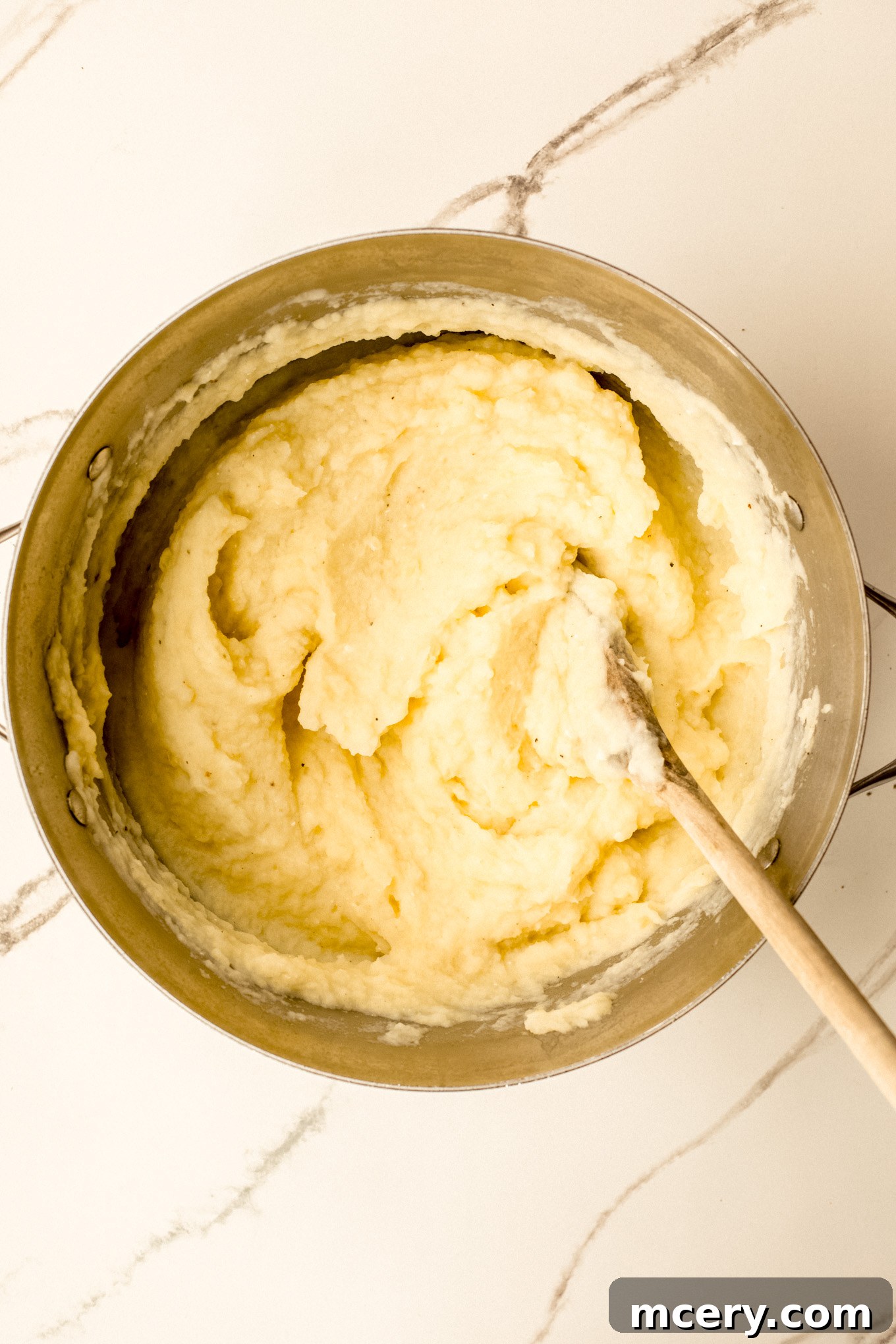 Silky Yukon Gold Mash 9 Finished creamy mashed potatoes in a stockpot, perfectly combined and ready to be seasoned and served.