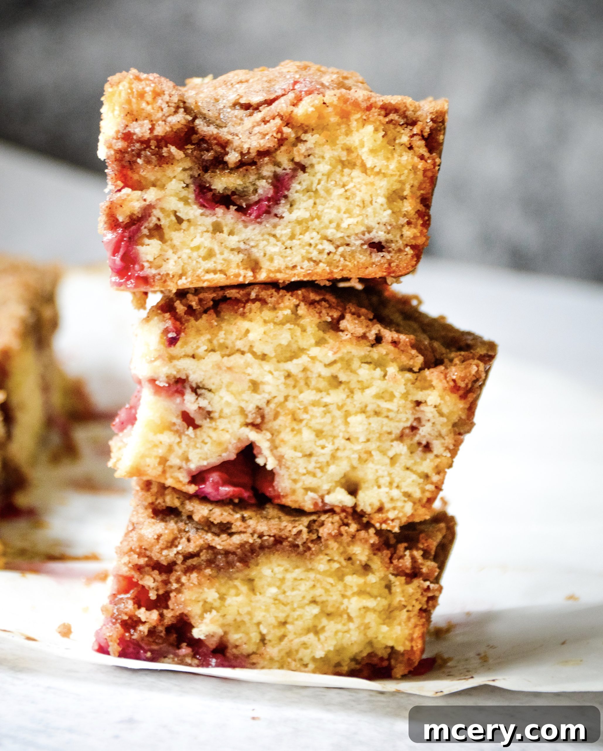 Strawberry Crumb Coffee Cake 2 A freshly baked Strawberry Coffee Cake, with a rich crumbly streusel topping, visible juicy red strawberries, and a moist, golden-brown interior.