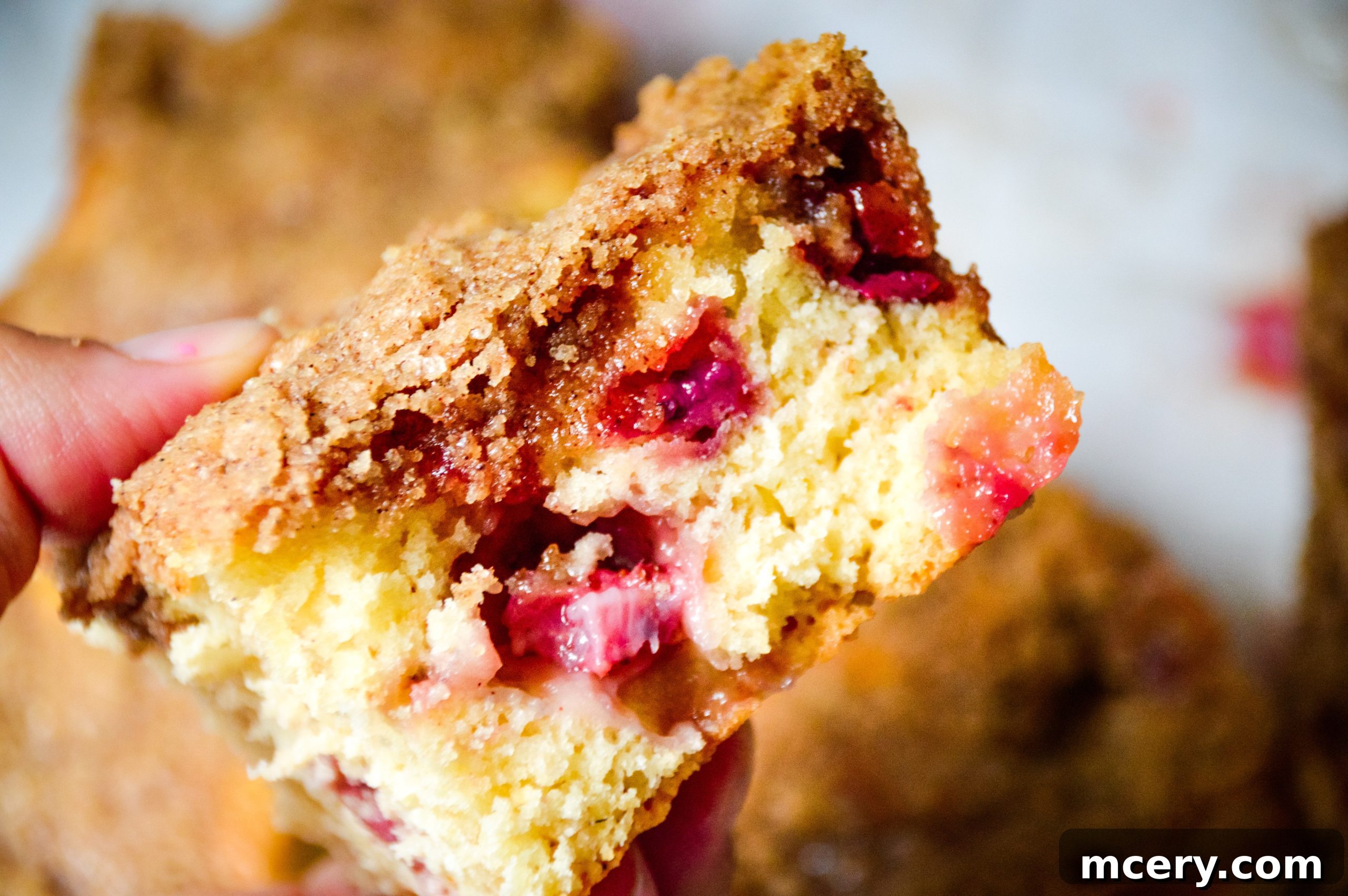 Strawberry Crumb Coffee Cake 3 Close-up of a bowl filled with fresh, vibrant red strawberries, glistening with water droplets after being washed, ready for baking.