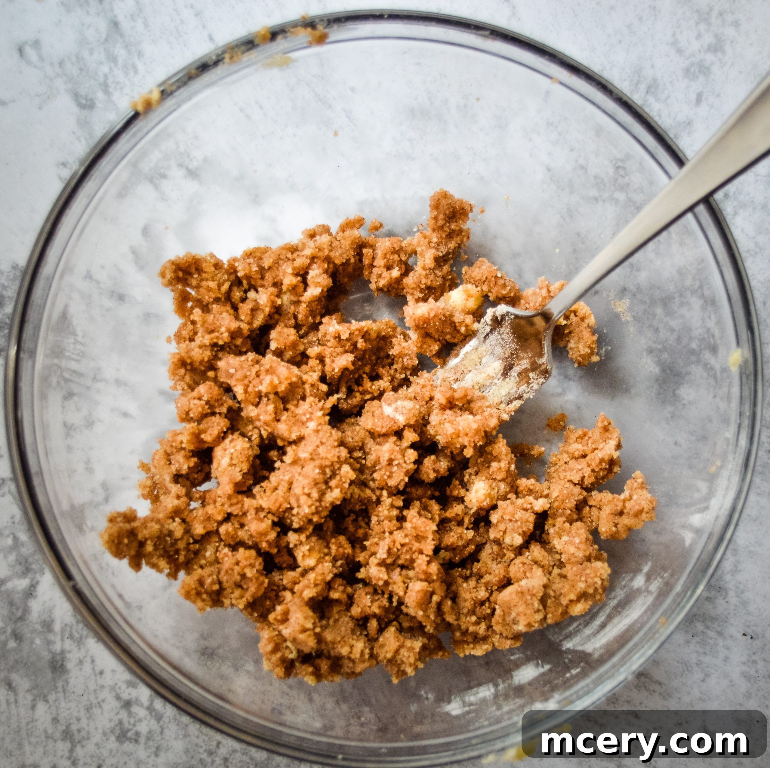 Strawberry Crumb Coffee Cake 8 Streusel topping ingredients being mixed in a bowl with a fork, showing the desired crumbly texture before being added to the cake.