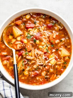 white bowl with vegetable soup and a side of a spoon.